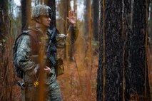 Senior Airman Gregory Cerny, 1st Combat Camera Squadron broadcaster, signals for a halt during the Ability to Survive and Operate exercise Jan. 14, 2014, at North Auxiliary Air Field, S.C. The exercise was organized to sharpen Airmen’s skills and their ability to operate as combat documentation specialists outside the wire. (U.S. Air Force photo/ Airman 1st Class Clayton Cupit)