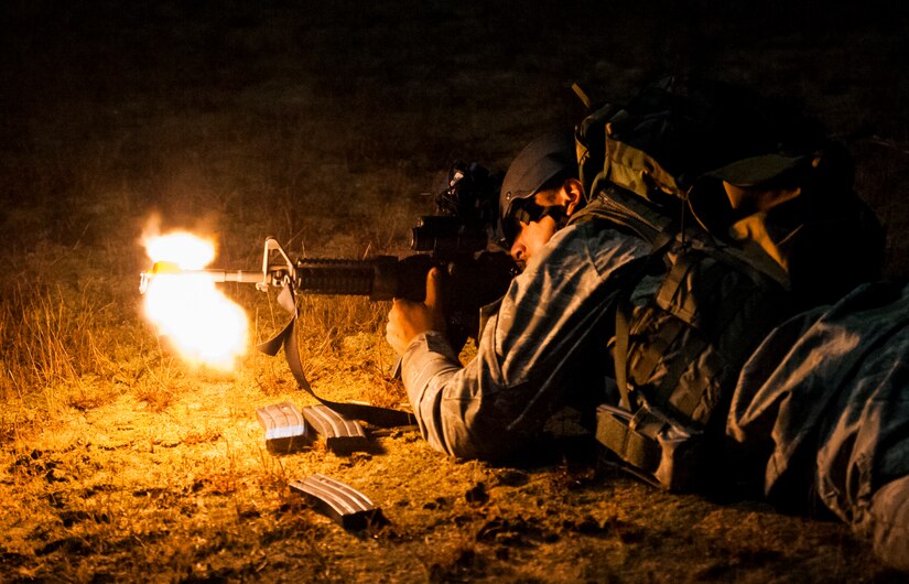 Airman 1st Class Jacob Albers, 1st Combat Camera Squadron photojournalist, fires his M-4 carbine rifle with a suppressor on the front at enemy forces during the night tactical potion of the Ability to Survive and Operate exercise Jan. 14, 2014, at North Auxiliary Air Field, S.C. The 1st Combat Camera Squadron located at Joint Base Charleston, S.C., hosted the Ability to Survive and Operate Exercise from Jan. 6 through 17. (U.S. Air Force photo/ Senior Airman Dennis Sloan)