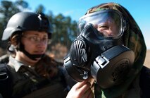 Staff Sgt. Michelle DeMers, 1st Combat Camera Squadron broadcaster, helps Senior Airman Barbara Aguirre, 2nd CTCS broadcaster, during the Ability to Survive and Operate exercise Jan. 17, 2014, at North Auxiliary Air Field, S.C. The 1st Combat Camera Squadron located at Joint Base Charleston, S.C., hosted the Ability to Survive and Operate Exercise from Jan. 6 through 17. (U.S. Air Force photo/ Airman 1st Class Clayton Cupit)