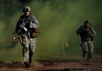 Senior Airman Gregory Cerny, 1st Combat Camera Squadron broadcaster, runs through smoke used for cover as he and his team crosses a field during the tactical portion of the Ability to Survive and Operate exercise Jan. 14, 2014, at North Auxiliary Air Field, S.C. The 1st Combat Camera Squadron located at Joint Base Charleston, S.C., hosted the Ability to Survive and Operate Exercise from Jan. 6 through 17. (U.S. Air Force photo/ Senior Airman Dennis Sloan)