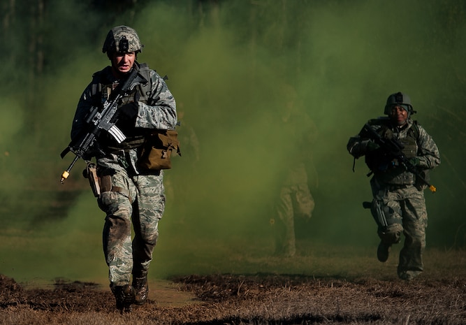 Senior Airman Gregory Cerny, 1st Combat Camera Squadron broadcaster, runs through smoke used for cover as he and his team crosses a field during the tactical portion of the Ability to Survive and Operate exercise Jan. 14, 2014, at North Auxiliary Air Field, S.C. The 1st Combat Camera Squadron located at Joint Base Charleston, S.C., hosted the Ability to Survive and Operate Exercise from Jan. 6 through 17. (U.S. Air Force photo/ Senior Airman Dennis Sloan)