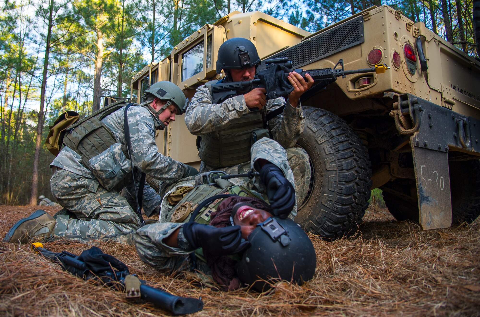 Airmen from the 1st, 2nd and 3rd Combat Camera Squadrons participate in a scenario involving medical procedures under fire during the tactical portion of the Ability to Survive and Operate exercise Jan. 15, 2014, at North Auxiliary Air Field, S.C. The 1st Combat Camera Squadron located at Joint Base Charleston, S.C., hosted the Ability to Survive and Operate Exercise from Jan. 6 through 17, inviting all Air Force combat camera squadrons to attend. (U.S. Air Force photo/ Airman 1st Class Clayton Cupit)