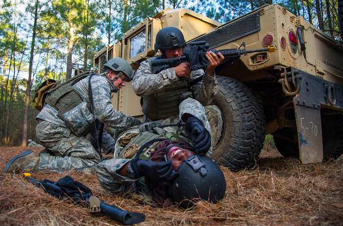 Airmen from the 1st, 2nd and 3rd Combat Camera Squadrons participate in a scenario involving medical procedures under fire during the tactical portion of the Ability to Survive and Operate exercise Jan. 15, 2014, at North Auxiliary Air Field, S.C. The 1st Combat Camera Squadron located at Joint Base Charleston, S.C., hosted the Ability to Survive and Operate Exercise from Jan. 6 through 17, inviting all Air Force combat camera squadrons to attend. (U.S. Air Force photo/ Airman 1st Class Clayton Cupit)