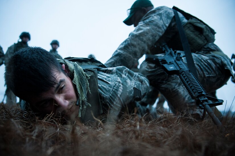 Tech. Sgt. David Alderete, 1st Combat Camera Squadron maintainer, is placed on the ground with his hands behind his back by Tech. Sgt. DeNoris Mickle, 1st Combat Camera Squadron photo element lead, during the tactical operations portion of the Ability to Survive and Operate exercise Jan. 14, 2014, at North Auxiliary Air Field, S.C. Mickle was demonstrating the proper safety procedures of searching a detainee or person of interest. The ATSO exercise was designed to sharpen Airmen’s skills and their ability to operate as combat documentation specialists in hostile environments. (U.S. Air Force photo/ Senior Airman Dennis Sloan)
