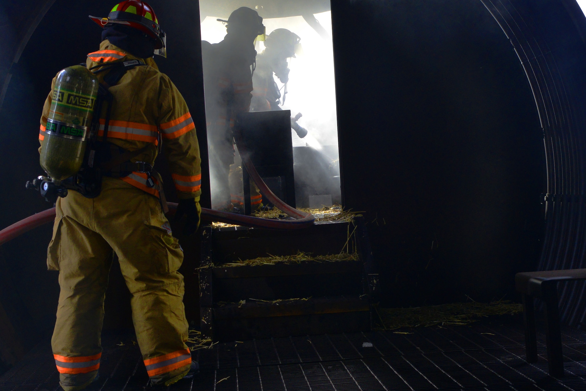 U.S. Air Force firefighters hose down a fire during training, Shaw Air Force Base, S.C., Jan. 13, 2014. As a part of the exercise the Airmen had to remove a simulated human being from the burning plane while also putting the fire. (U.S. Air Force photo by Senior Airman Ashley L. Gardner/Released)