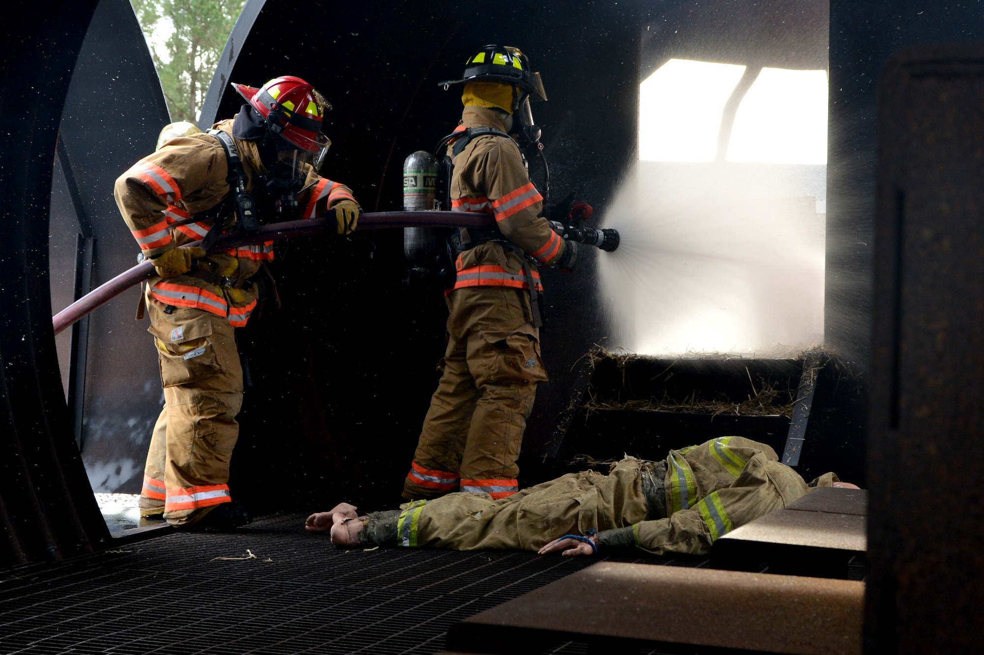[From left] U.S. Air Force Staff Sgt. Alex Vasquez, 20th Civil Engineer Squadron firefighter and Airman 1st Class Clayton Angleoff, 20th Civil Engineer Squadron firefighter hose down a fire during training, Shaw Air Force Base, S.C., Jan. 13, 2014. As a part of the exercise the Airmen had to remove a simulated human being from the burning plane while also putting the fire. (U.S. Air Force photo by Senior Airman Ashley L. Gardner/Released)
