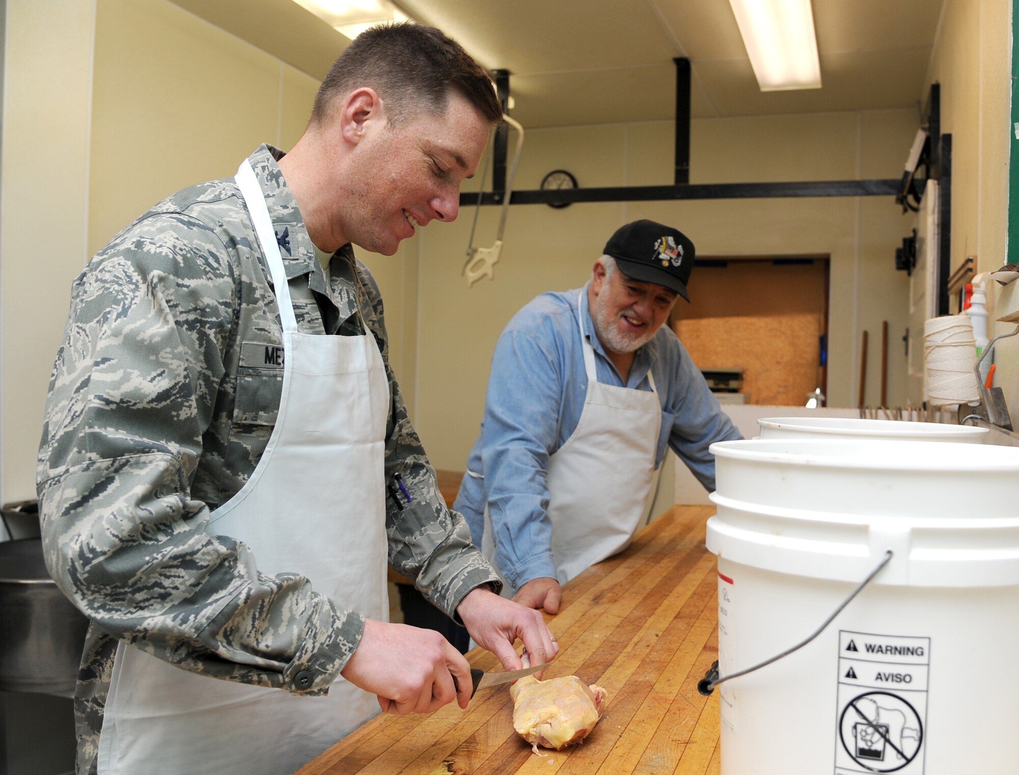 Col. Alex Mezynski, 5th Bomb Wing commander, cuts up meat for the Sportsman's Feed Jan. 17, 2014. The Sportsman's Feed was held at the Jimmy Doolittle Center on Jan. 19, 2014 with many individuals attending the event. (U.S. Air Force photo/Airman 1st Class Andrew Crawford)