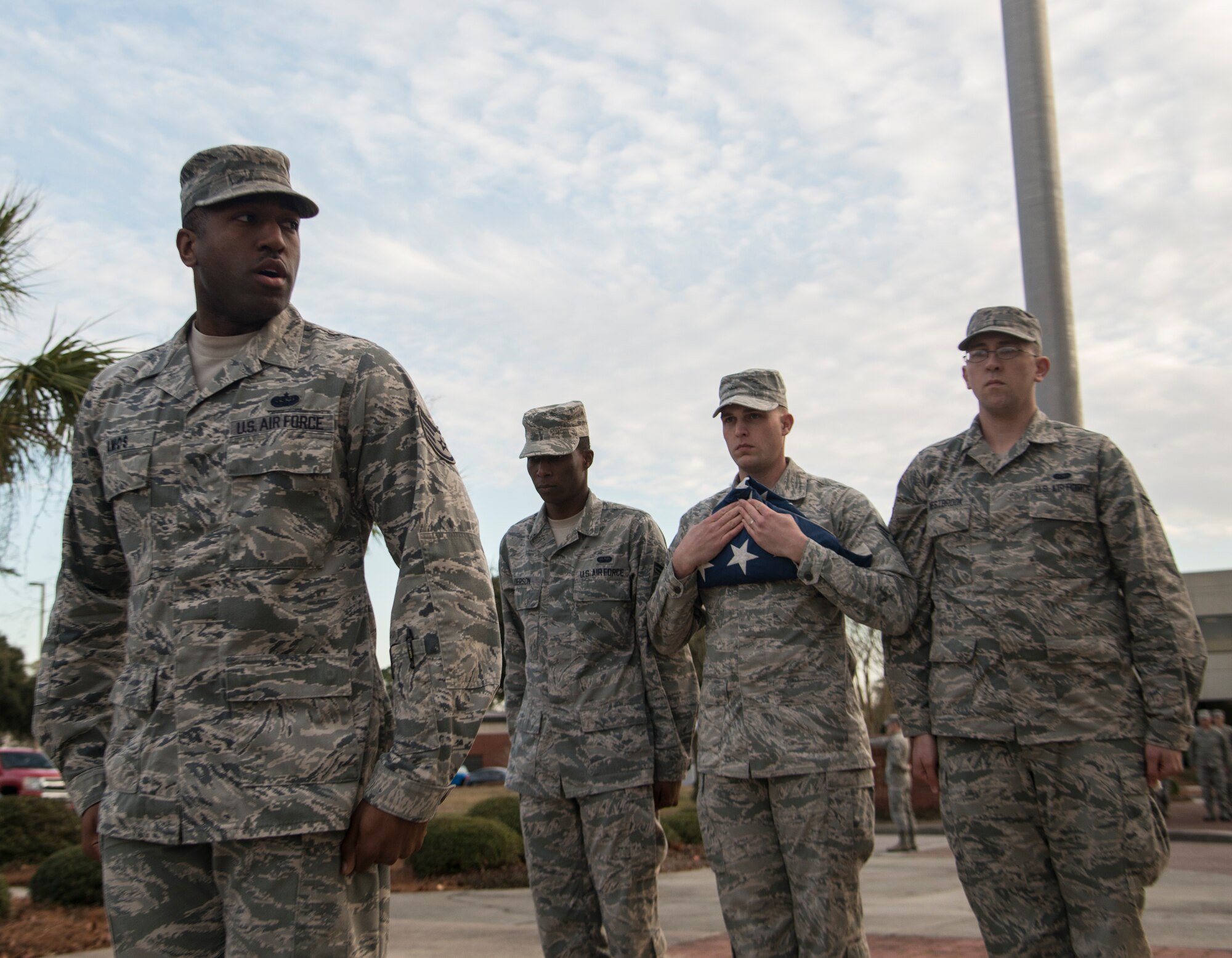Staff Sgt. Spencer Amos, 628th Communications Squadron noncommissioned officer-in-charge of the detail under watch, calls the command to march the flag to the flight commander during a retreat ceremony  Jan. 21, 2014, at Joint Base Charleston - Air Base, S.C. During retreat, a two-man fold is conducted after the playing of the national anthem, with the NCO of the detail under watch. After it is meticulously folded into its final form the flight commander orders the colors to be retired, signifying the end of the duty day. (U.S. Air Force photo/Tech. Sgt. Rasheen Douglas)

