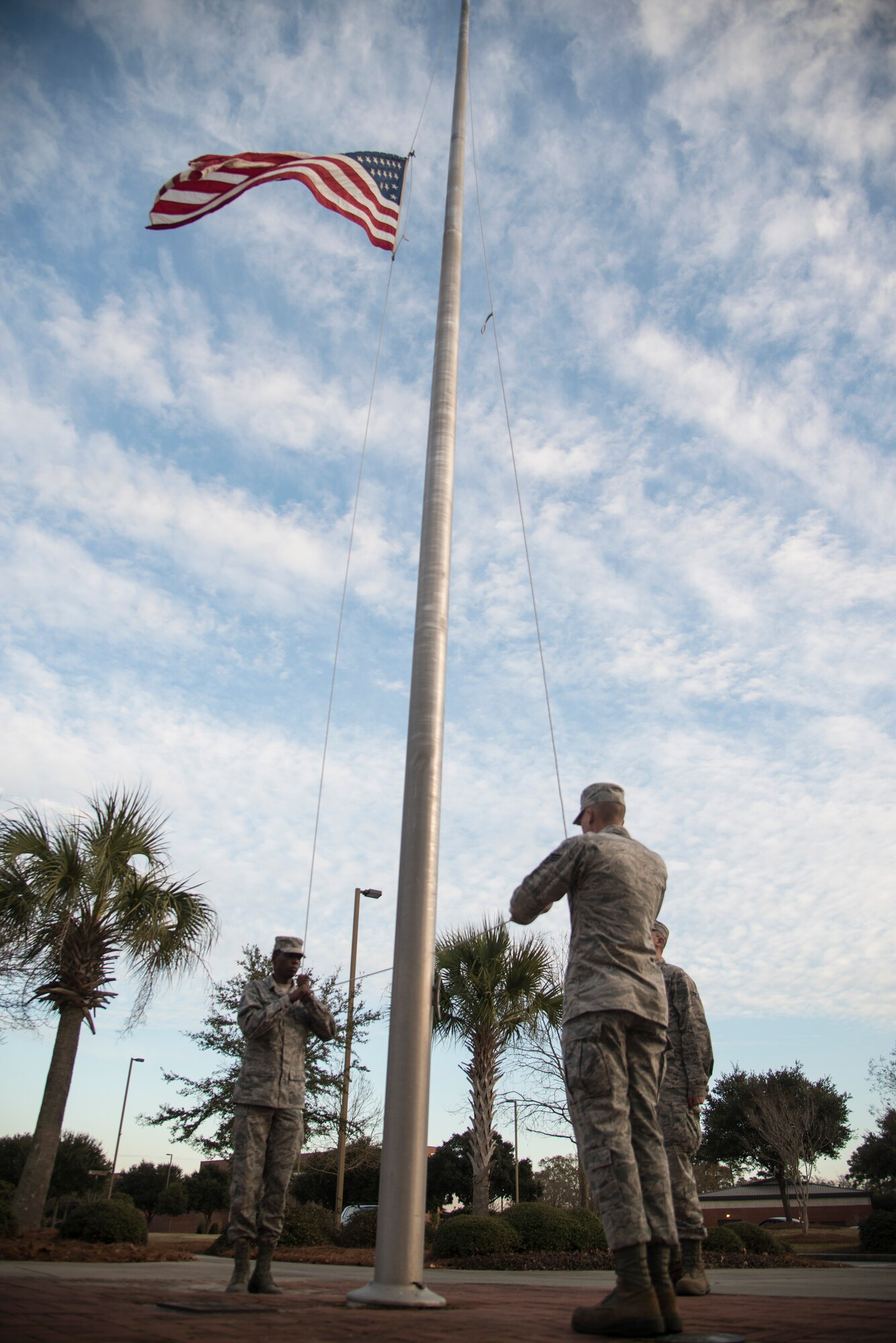 (Left to right), Airmen 1st Class Robert Andersen, Joshua Westbrook, and Senior Airman Robert Wessinger, lower the American flag during a Retreat ceremony Jan. 21, 2014, at Joint Base Charleston - Air Base, S.C. The Retreat ceremony is coordinated so the playing of the National Anthem and the lowering of the American flag are completed at the same time. Amos, Westbrook, and Wessinger are members of the 628th Communications Squadron. (U.S. Air Force photo/Tech. Sgt. Rasheen Douglas)