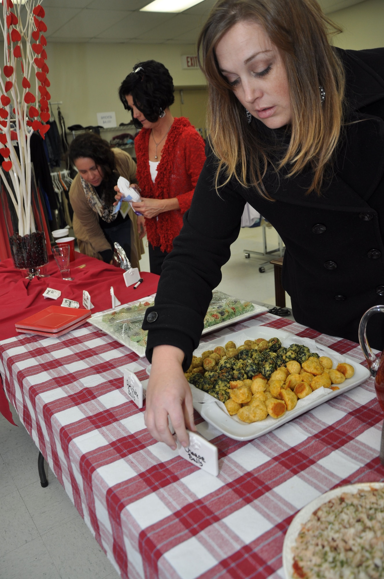 GOODFELLOW AIR FORCE BASE, Texas – Goodfellow Combined Spouses’ Club members set up the refreshments table during the SAMS Thrift Store grand opening Jan. 16. The grand opening included a ribbon cutting, fashion show, shopping and refreshments. (U.S. Air Force photo/ Airman 1st Class Breonna Veal)