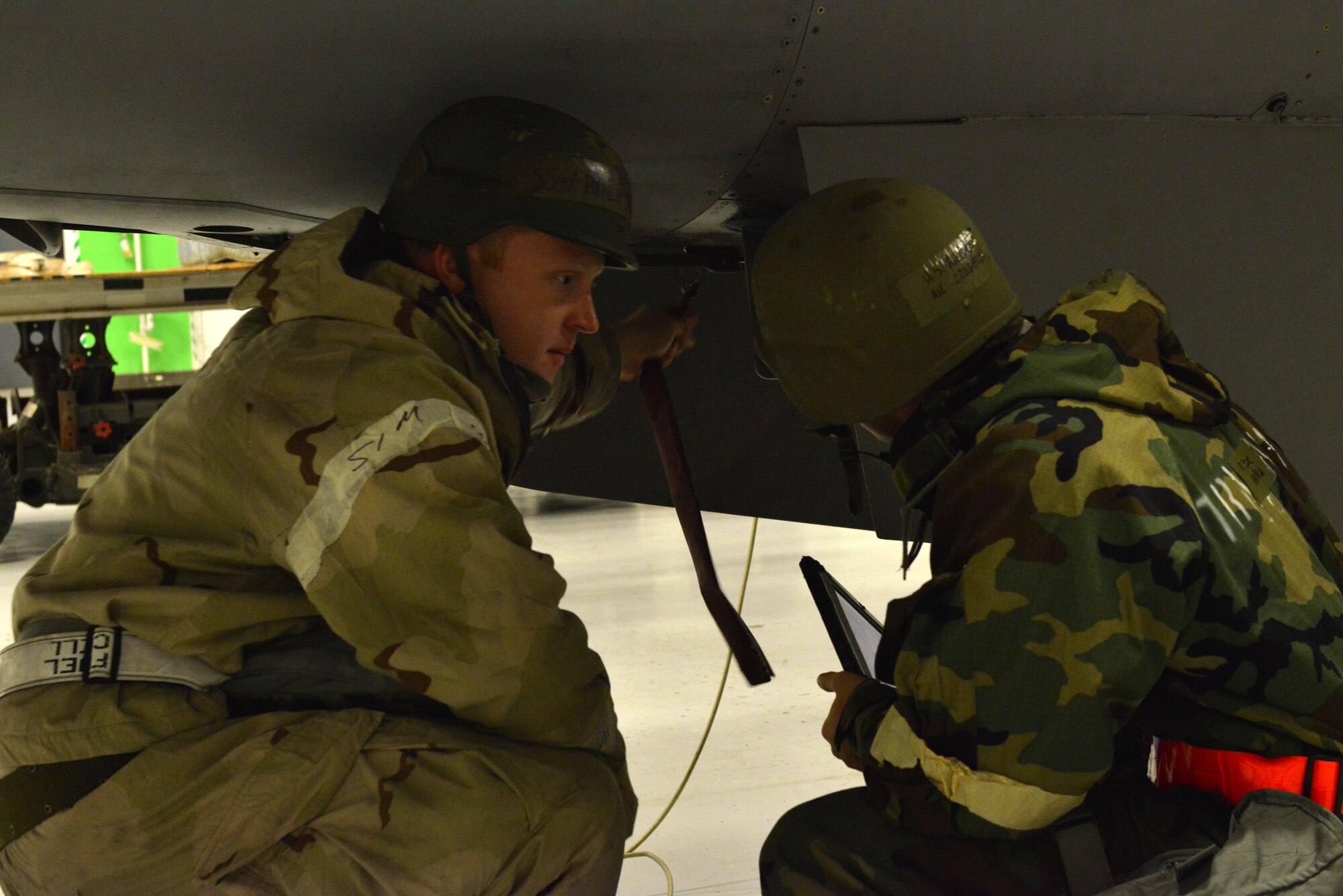 [From left] U.S. Air Force Staff Sgt. Phillip Turnage, 20th Logistics Readiness Squadron aircraft fuels systems journeyman, trains Airman 1st Class Jared Coughlin 20th LRS aircraft fuels systems apprentice, on aircraft safety at Shaw Air Force Base, S.C., Jan. 14, 2014.  Turnage gave Coughlin the aircraft fuels system "safe for maintenance" training while participating in an operational readiness exercise. (U.S. Air Force photo by Airman 1st Class Jensen Stidham/Released)