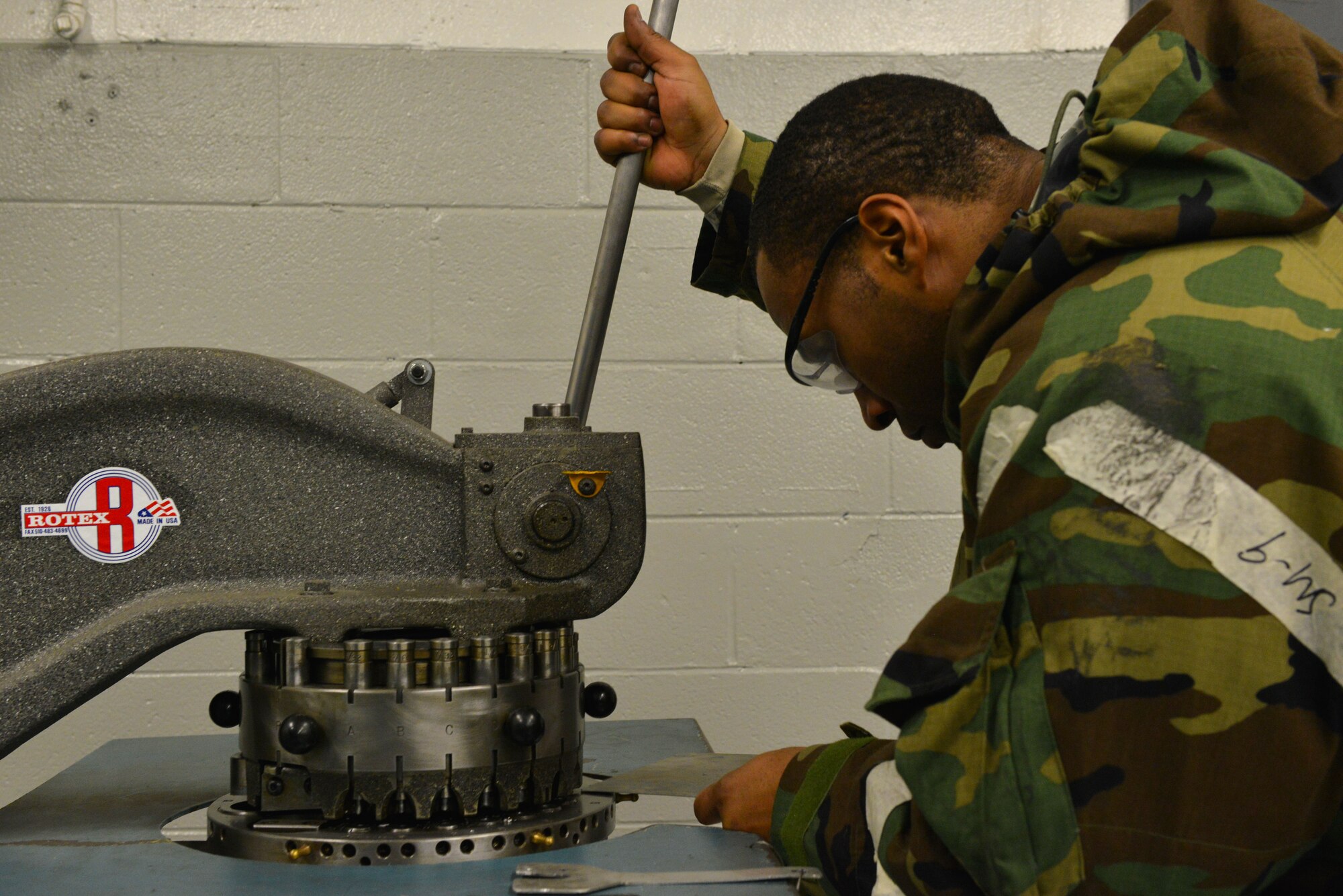 U.S. Air Force Staff Sgt. Daniel Brandon, 20th Equipment Maintenance Squadron aircraft special maintenance journeyman, uses a sheet metal hole punch at Shaw Air Force Base, S.C., Jan. 14, 2014. Brandon was fabricating a new heat shield to be installed as a wire protector in an F-16 Fighting Falcon, while also participating in an operational readiness exercise. (U.S. Air Force photo by Airman 1st Class Jensen Stidham/Released)