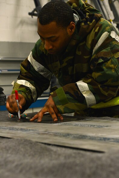 U.S. Air Force Staff Sgt. Daniel Brandon, 20th Equipment Maintenance Squadron aircraft special maintenance journeyman, traces a metal heat shield at Shaw Air Force Base, S.C., Jan. 14, 2014. Brandon was fabricating a new heat shield to be installed as a wire protector in an F-16 Fighting Falcon, while also participating in an operational readiness exercise. (U.S. Air Force photo by Airman 1st Class Jensen Stidham/Released)