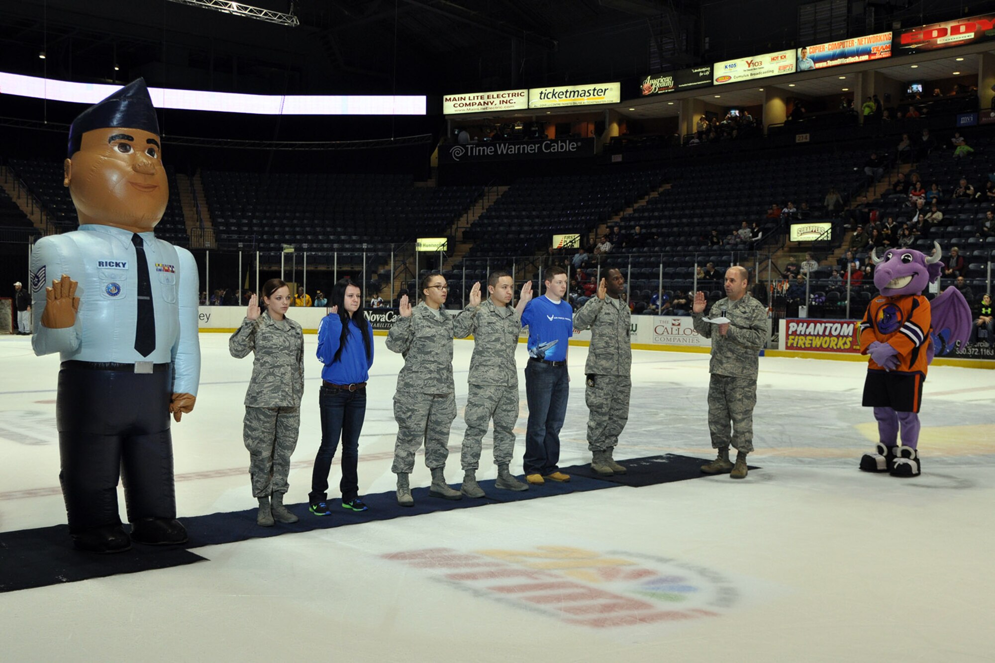 YOUNGSTOWN, Ohio -- Air Force Reserve Col. James Dignan, commander of the 910th Airlift Wing, gives the oath of enlistment to some of the 910th Airlift Wing's newest members during a Youngstown Phantoms hockey game at the Covelli Centre here, Jan. 11, 2014, while Air Force Reserve mascot, Airman Ricky, and Phantoms mascot, Sparky, look on. Nearly 100 Citizen Airmen, based at nearby Youngstown Air Reserve Station, Ohio, participated in YARS Night Out activities before and during the game. The Phantoms, a member of the United States Hockey League, defeated Team USA 6-3 in front of a crowd of more than 1200 people. U.S. Air Force photo by Master Sgt. Bob Barko Jr.