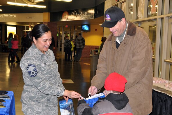 YOUNGSTOWN, Ohio -- Air Force Reserve Senior Master Sgt. Joann Shaw, Youngstown Air Reserve Station Air Force Reserve Recruiting Flight Chief, hands some USAFR pencils to a young fan near the YARS Recruiting Flight’s concourse display table during pre-game festivities for a Youngstown Phantoms hockey game at the Covelli Centre here, Jan. 11, 2014. Nearly 100 Citizen Airmen, based at nearby Youngstown Air Reserve Station, Ohio, participated in YARS Night Out activities before and during the game. The Phantoms, a member of the United States Hockey League, defeated Team USA 6-3 in front of a crowd of more than 1200 people. U.S. Air Force photo by Master Sgt. Bob Barko Jr.