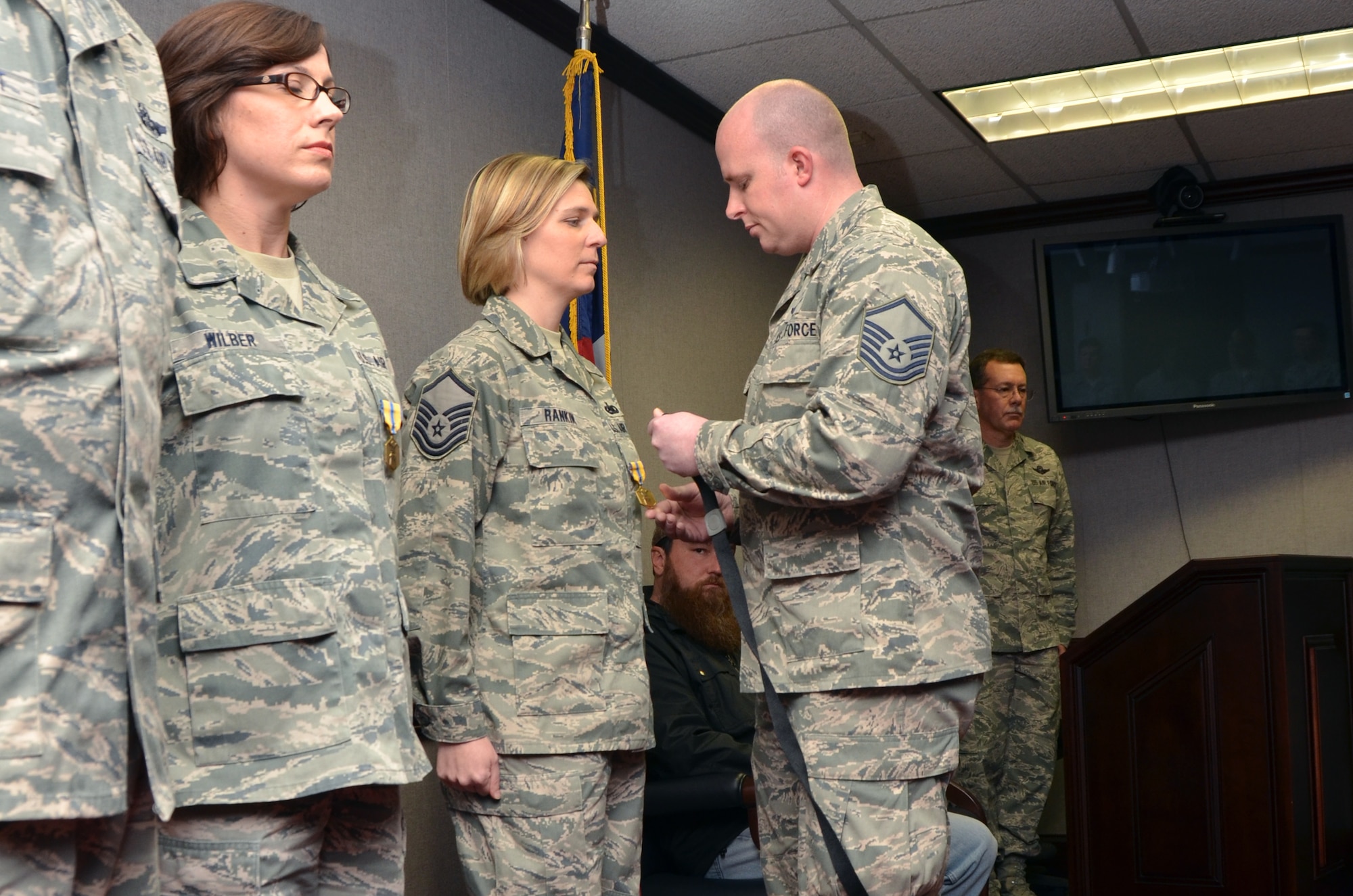 U.S. Air Force Master Sgt. Tracie Rankin, 1st Sergeant for the 145th Mission Support Group, receives Air Force Commendation Medal, as she is recognized for her contributions as Family Liaison Officer to MAFFS 7 survivor, Master Sgt. Josh Marlowe, loadmaster for the 156th Airlift Squadron.  Marlowe pins medal onto Rankin during an emotional ceremony held at the North Carolina Air National Guard base, Charlotte-Douglas Intl. airport, January 11, 2014. (Air National Guard photo by Master Sgt. Patricia F. Moran, 145th Public Affairs/Released)
