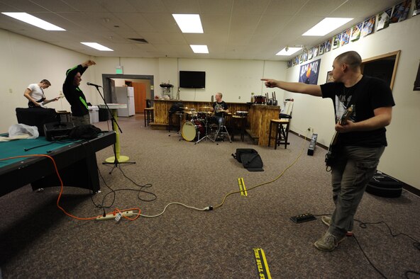 Senior Airman Matthew Phillips, 5th Munitions Squadron munitions stockpile technician and guitarist for RedBall, points to Airman 1st Class Slate Garner, 5th MUNS weapons load crewmember, during band practice at Minot Air Force Base, N.D., Sept. 9, 2013. Phillips and Garner have been performing with the group for approximately one year. The bands next show will be at the Maintenance Professional of the Year ceremony to be hosted in Dock 9, Feb. 28, 2014. (U.S. Air Force photo/Senior Airman Stephanie Sauberan)