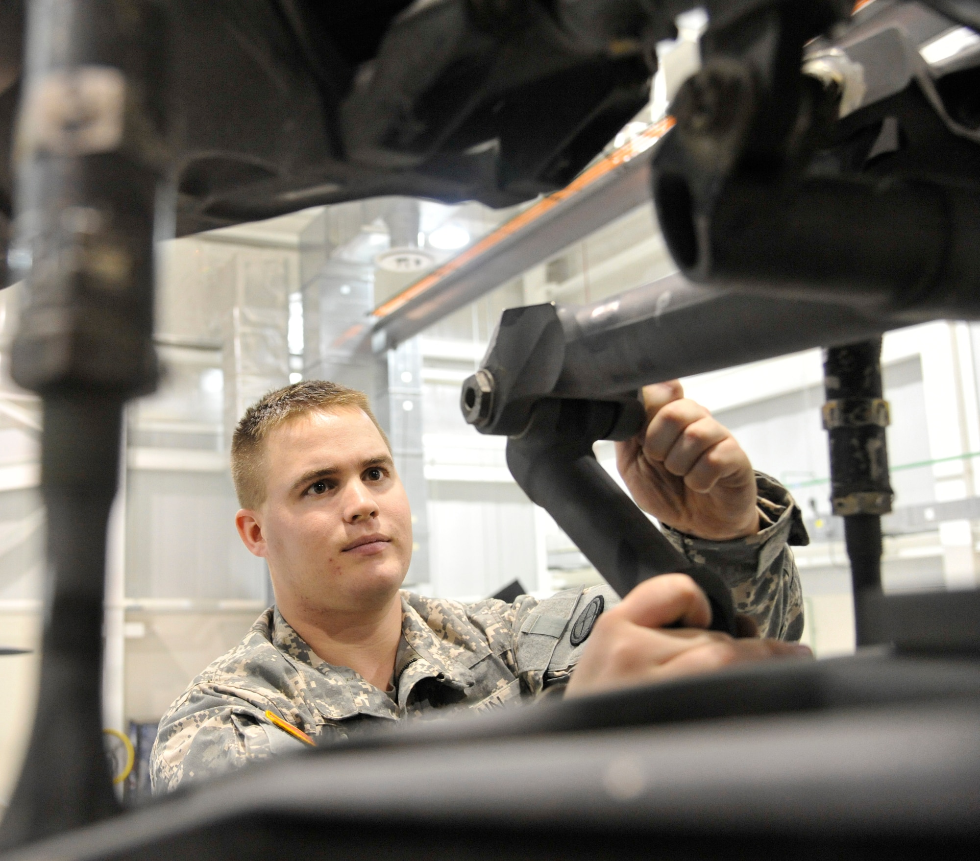 U.S. Army Spc. Todd Gann, 1-135th Attack/Reconnaissance Battalion aircraft maintainer, checks for axial play within the bushing of an AH-64 Apache at Whiteman Air Force Base, Mo., Jan. 9, 2014. This inspection ensures that aircraft maintains its structural integrity while in flight. (U.S. Air Force photo by Airman 1st Class Keenan Berry/Released)