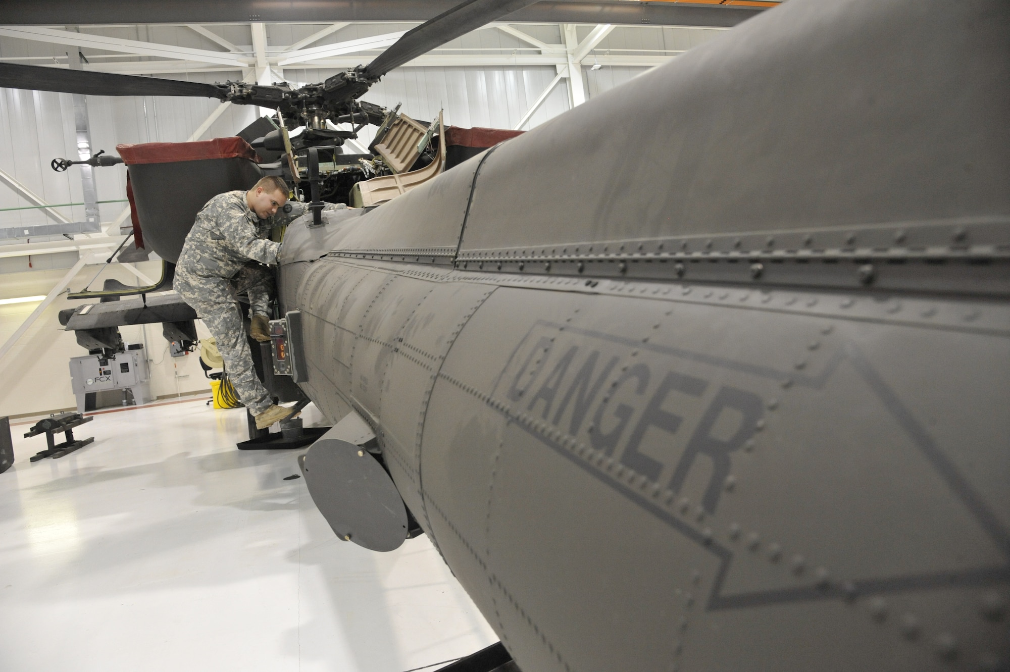 U.S. Army Spc. Todd Gann, 1-135th Attack/Reconnaissance Battalion aircraft maintainer, checks bearings for axial movement within the tail of an AH-64
Apache at Whiteman Air Force Base, Mo., Jan. 9, 2014. This inspection ensures the aircraft will maintain its stability while in flight. (U.S. Air Force photo by Airman 1st Class Keenan Berry/Released)