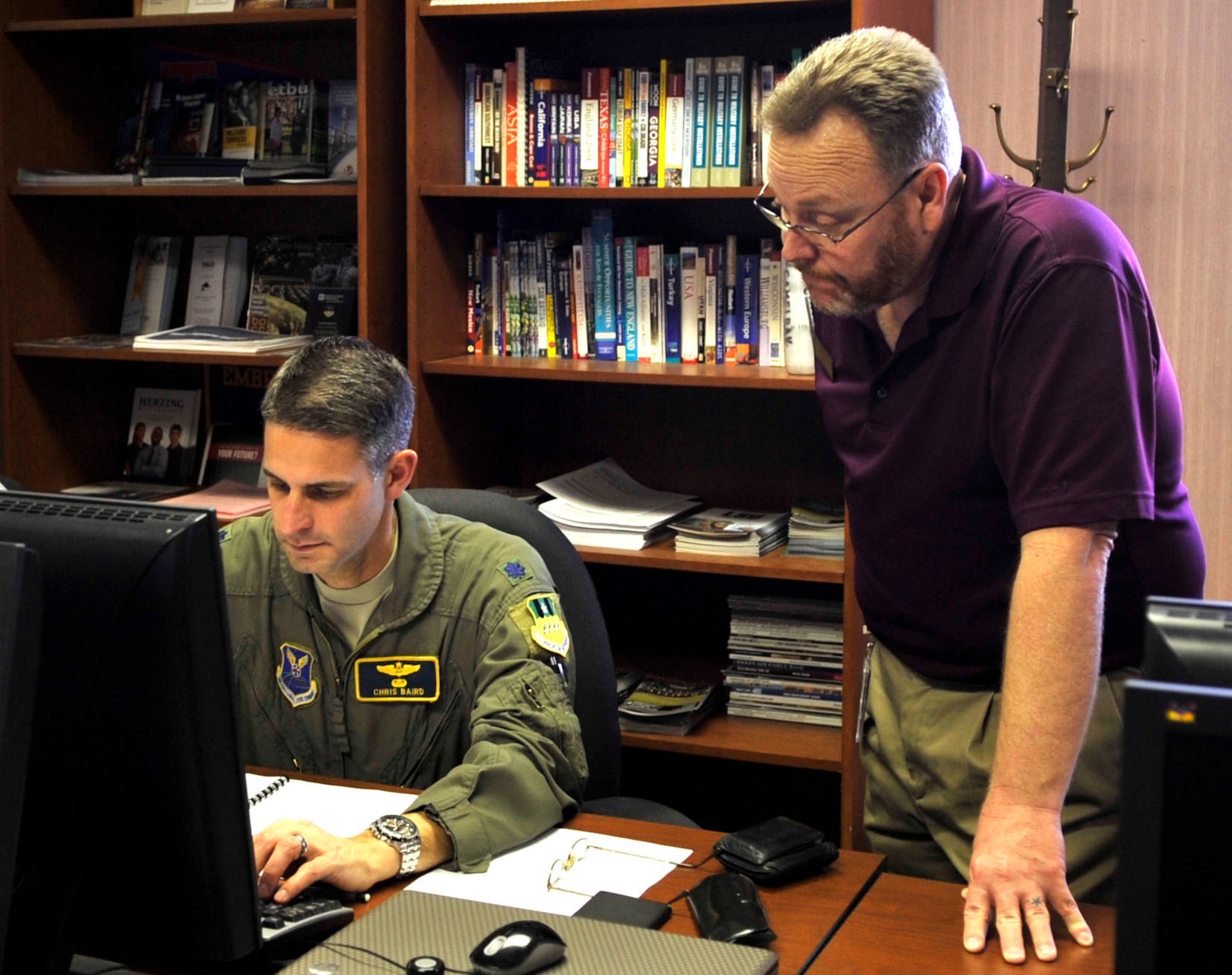 Rod Miller, Airman and Family Readiness Center community readiness consultant assists Lt. Col. Christopher Baird, 2nd Bomb Wing chief of advance programs, with a social media networking site on Barksdale Air Force Base, Jan. 14, 2014. With 2014 force-management programs, more Airmen will be able to use social media networking to seek employment. (U.S. Air Force photo/Airman 1st Class Benjamin Raughton)