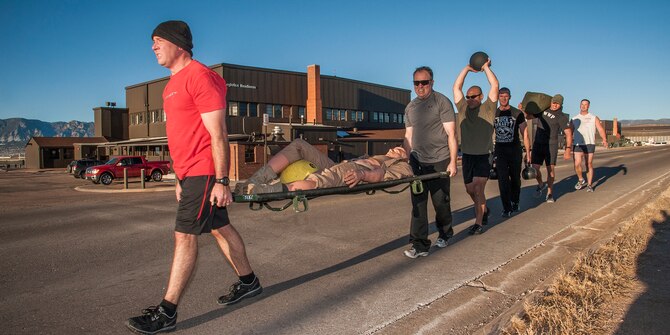PETERSON AIR FORCE BASE, Colo. -- Explosive ordnance disposal personnel (left to right) Senior Airman David Rediger, 302nd Civil Engineer Squadron Explosive Ordnance Disposal Flight, Staff Sgt. Daniel Jennings, 302nd CES, Master Sgt. Ross Kurashima, 302nd CES, Staff Sgt. Steven Fontana, 302nd CES, Senior Airman Darrell Linkus, 140th CES, Buckley AFB, and Master Sgt. Andrew LeBeau, 140th CES, take part in a grueling physical training session Dec. 13. During the 1.5 mile movement, the team rotated through different carries including sharing a 235-pound litter, a 20-pound medicine ball, a pair of 70-pound kettle bells and a 45-pound duffle bag. The hard work pays off when the EOD technicians are faced with difficult and demanding EOD requirements. (U.S. Air Force photo/Craig Denton)