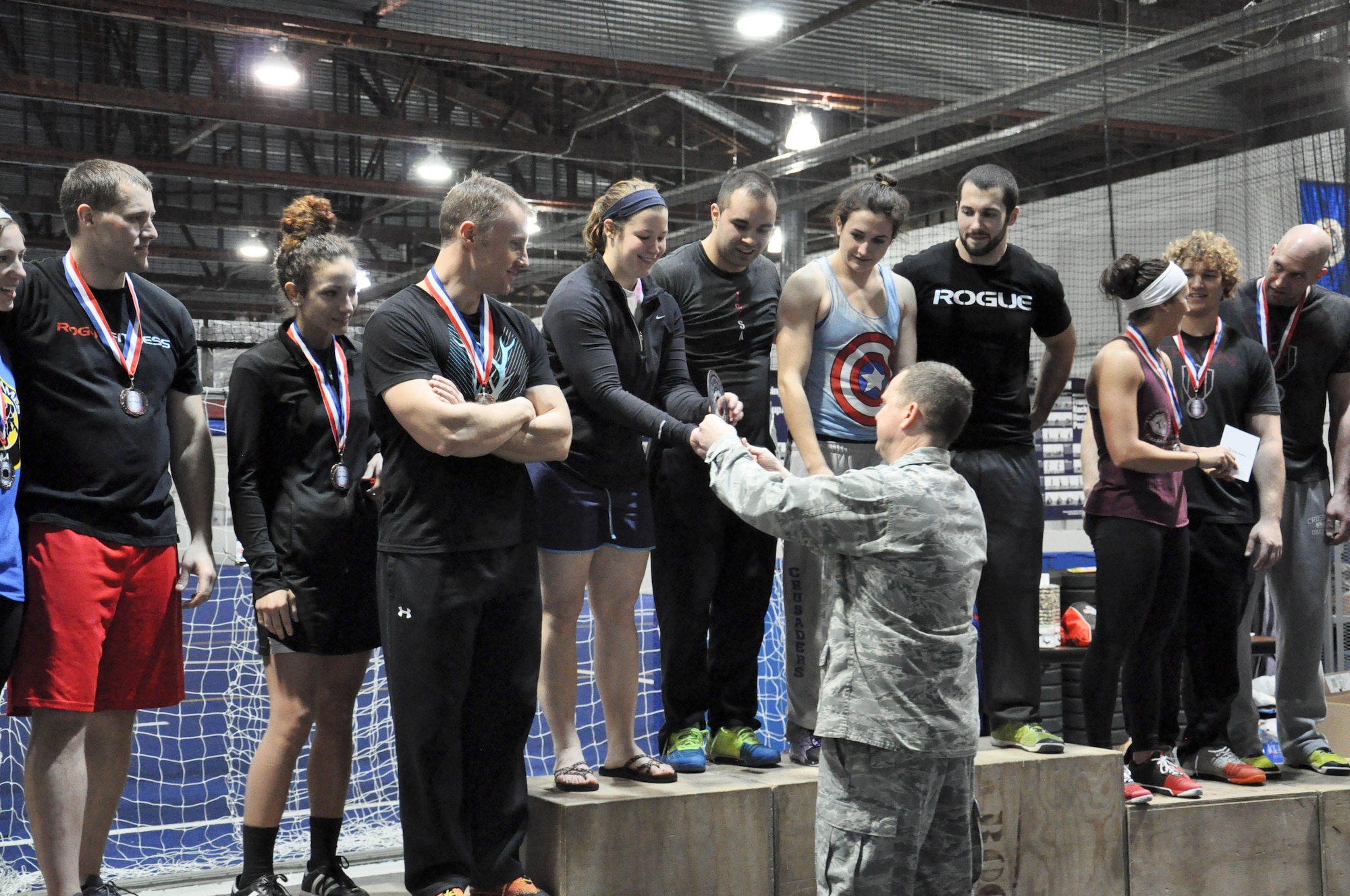 U.S. Air Force Col. Gregory Guillot, 55th Wing commander, hands Kristy Williams of The Misfits from CrossFit Vise Downtown a trophy for her team placing first place in the RX division of the 2014 TactFit Games at the Offutt Field House Jan. 19. The TactFit Games is a yearly CrossFit competition put on by Team Offutt Tactical Fitness to bring together athletes from the regions and to raise money for the TactFit program, which is ran completely by volunteers. (U.S. Air Force Photo by 2nd Lt. Carly A. Costello/Released)