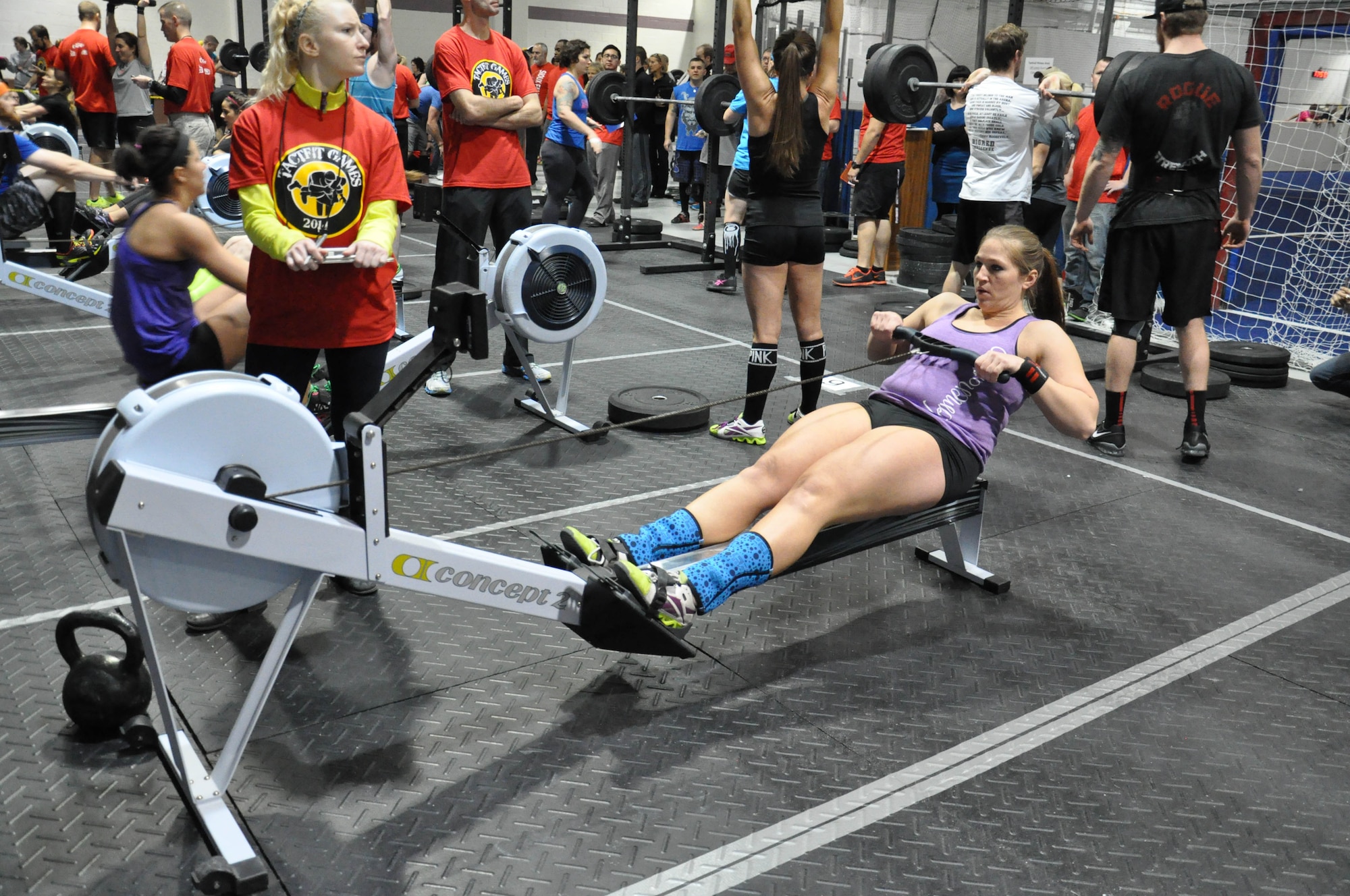 Angie Hobbs with Team Offutt Tactical Fitness rows for a calorie count during the second workout of the 2014 TactFit Games at the Offutt Field House Jan. 19.  Twenty five teams of four, two males and two females, competed in three high-intensity workouts that tested test their physical and mental limits with extreme fitness during the second annual TactFit Games. (U.S. Air Force Photo by 2nd Lt. Carly A. Costello/Released)