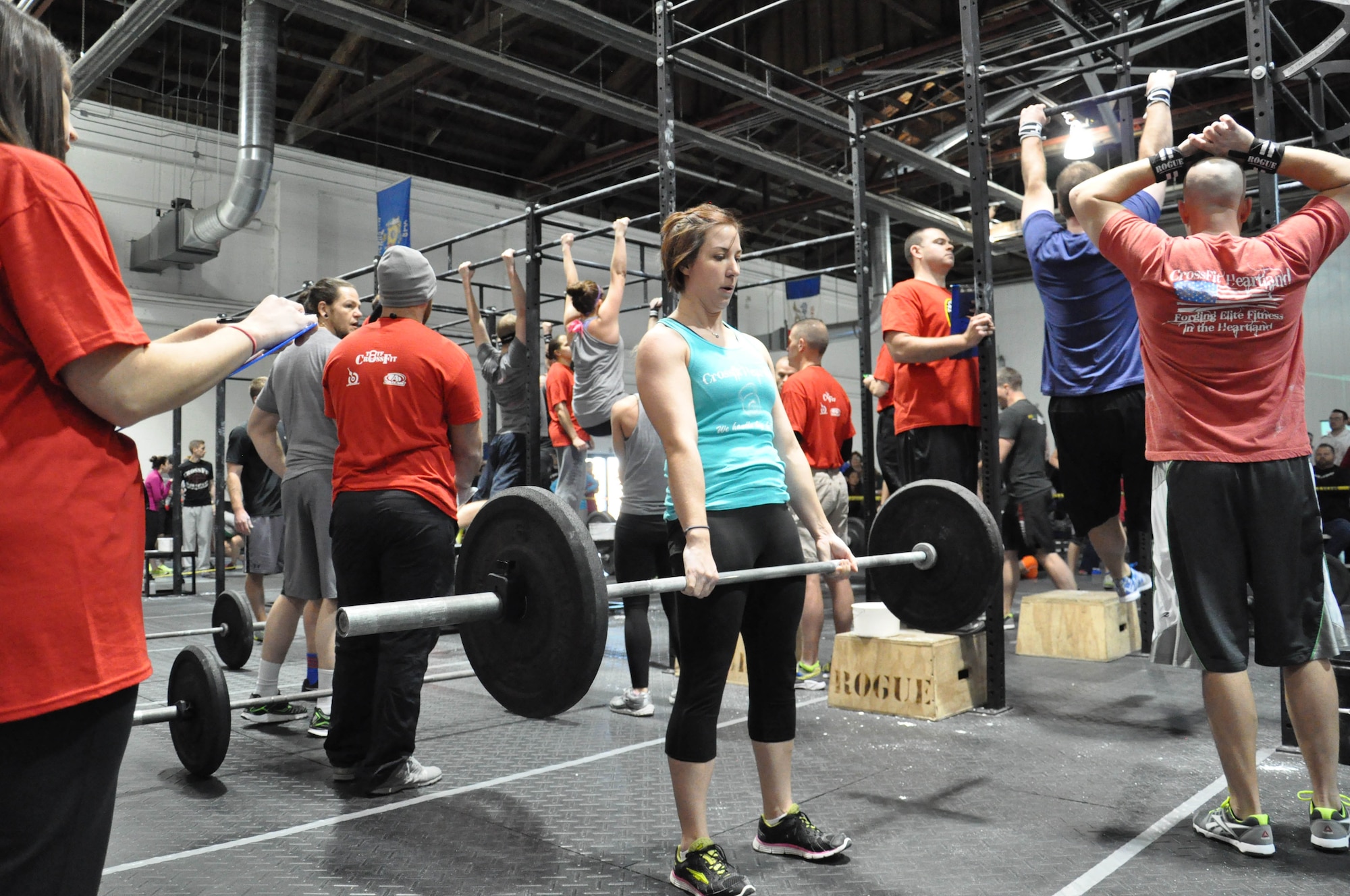 Vanessa Meloche from CrossFit Heartland shares the task of competing 55 deadlifts with her female partner Tami Reilly while their male partners complete 55 chest-to-bar pull ups during the first workout of the day of the 2014 TactFit Games Jan. 19 at the Offutt Field House. Teams had to complete 55 reps of five different movements and a 400-yard fireman’s carry in less than 15 minutes during the workout. (U.S. Air Force Photo by 2nd Lt. Carly A. Costello/Released)