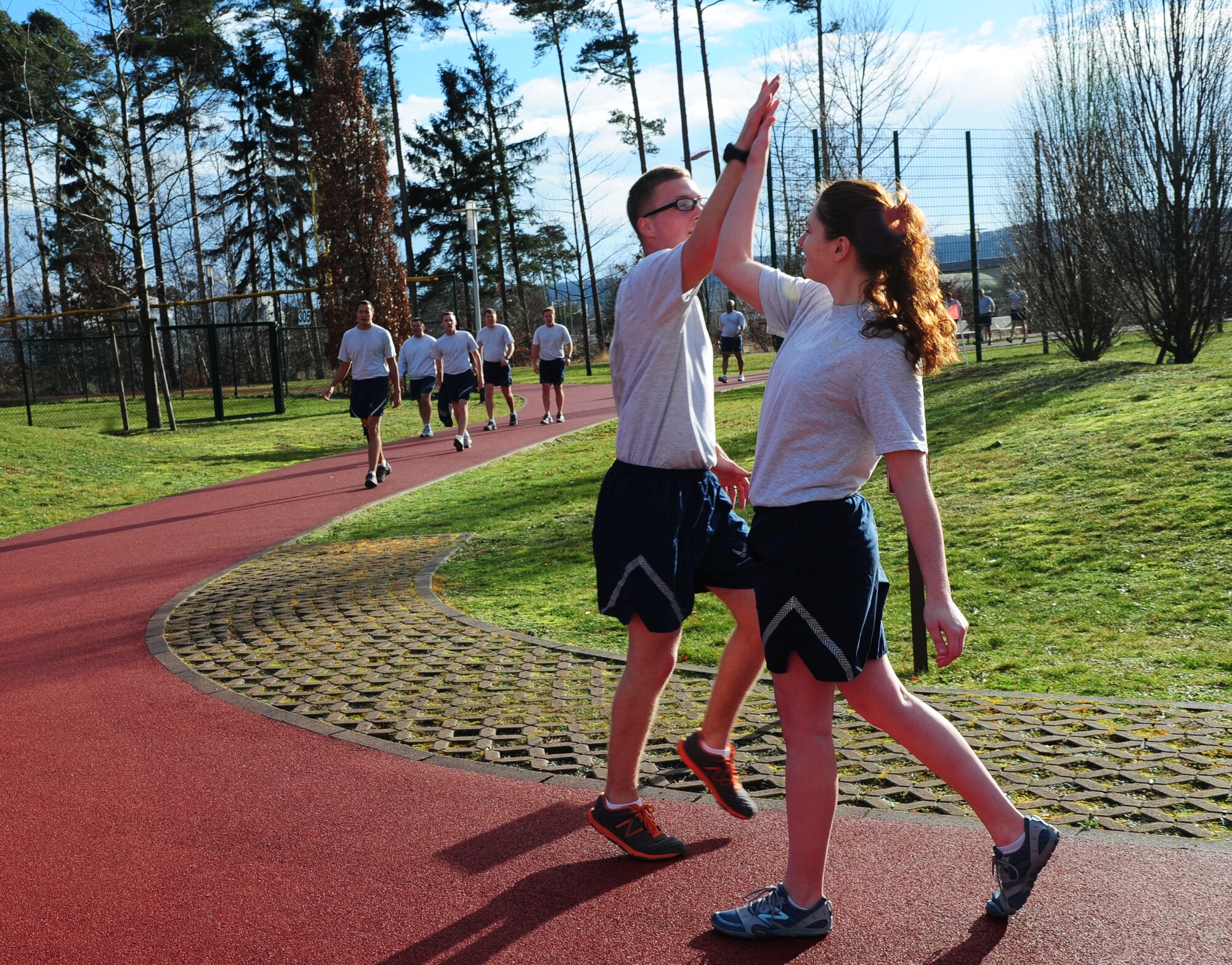 Airman 1st Class Chandler Marshall (right), 37th Airlift Squadron aviation resource management and certified physical training leader, high-fives a co-worker after a good workout Jan. 17, 2014, Ramstein Air Base, Germany. PTLs preform mock PT tests for their units, lead squadron approved fitness programs and they can provide assistance in the Fitness Assessment Cell to provide official testing to the installation. (U.S. Air Force photo/Senior Airman Hailey Haux)