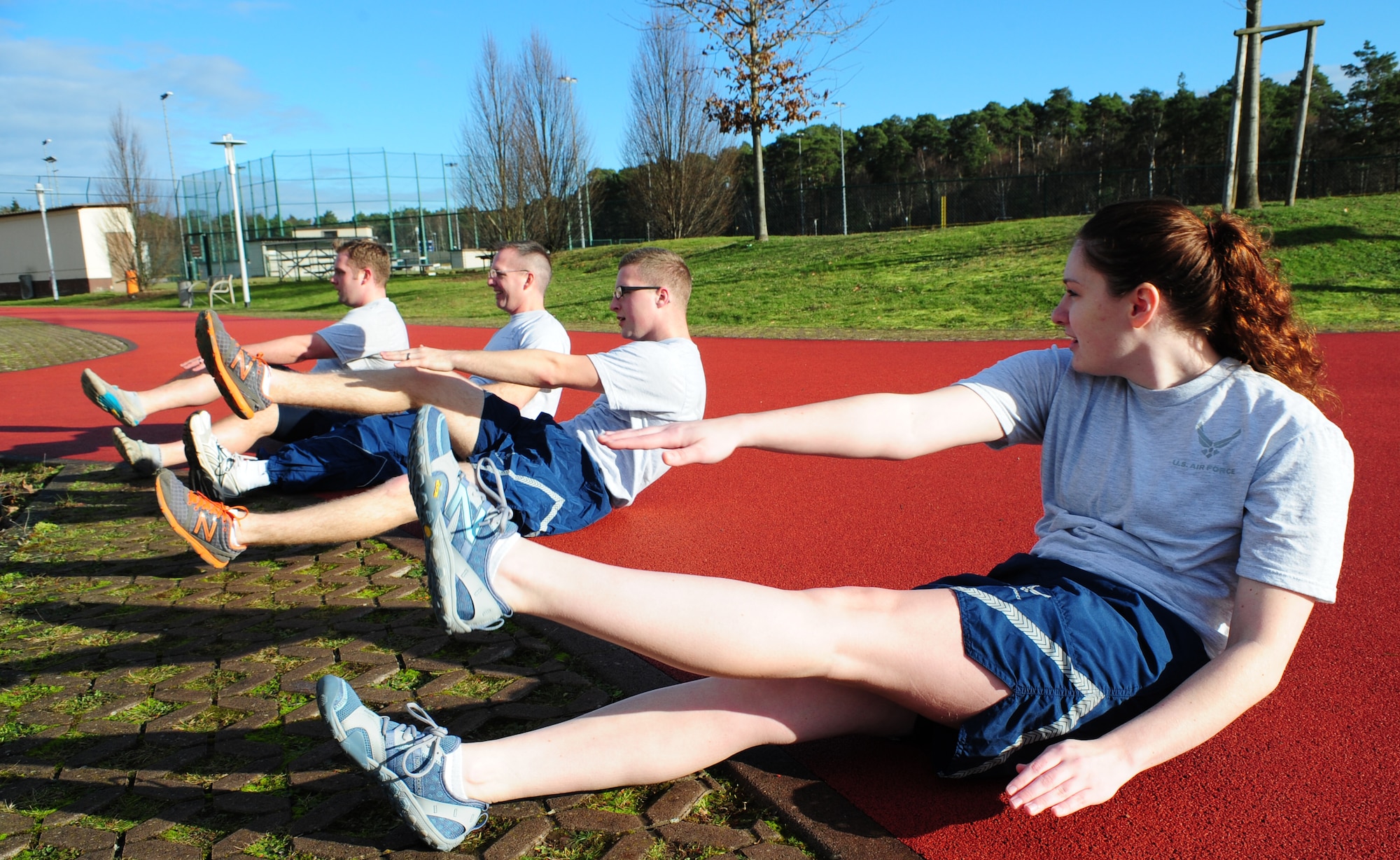 Airman 1st Class Chandler Marshall (right), 37th Airlift Squadron aviation resource management and certified physical training leader, trains with her unit during a workout session Jan. 17, 2014, Ramstein Air Base, Germany. PTLs preform mock PT tests for their units, lead squadron approved fitness programs and they can provide assistance in the Fitness Assessment Cell to provide official testing to the installation. (U.S. Air Force photo/Senior Airman Hailey Haux)