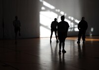 Senior Airman Jodi Parks, 37th Airlift Squadron physical training leader and loadmaster, leads co-workers in a warm-up before working out Jan. 17, 2014, Ramstein Air Base Germany. PTLs preform mock PT tests for their units, lead squadron approved fitness programs and they can provide assistance in the Fitness Assessment Cell to provide official testing to the installation. (U.S. Air Force photo/Senior Airman Hailey Haux)