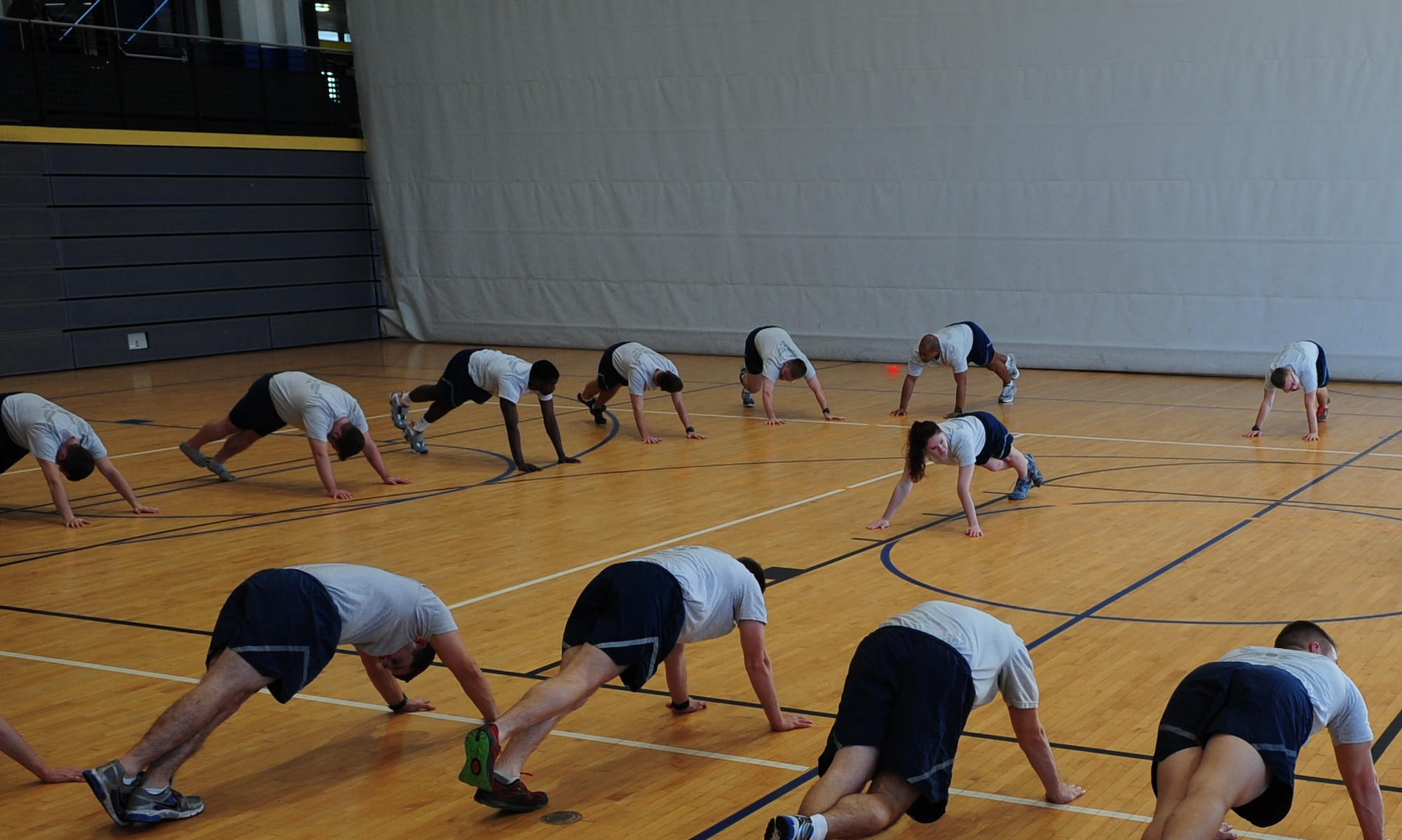 Airman 1st Class Chandler Marshall (center), 37th Airlift Squadron aviation resource management and certified physical training leader, leads her co-workers in stretches Jan. 17, 2014, Ramstein Air Base, Germany. PTLs preform mock PT tests for their units; lead squadron approved fitness programs and can provide assistance in the Fitness Assessment Cell to provide official testing to the installation. (U.S. Air Force photo/Senior Airman Hailey Haux)