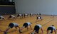 Airman 1st Class Chandler Marshall (center), 37th Airlift Squadron aviation resource management and certified physical training leader, leads her co-workers in stretches Jan. 17, 2014, Ramstein Air Base, Germany. PTLs preform mock PT tests for their units; lead squadron approved fitness programs and can provide assistance in the Fitness Assessment Cell to provide official testing to the installation. (U.S. Air Force photo/Senior Airman Hailey Haux)