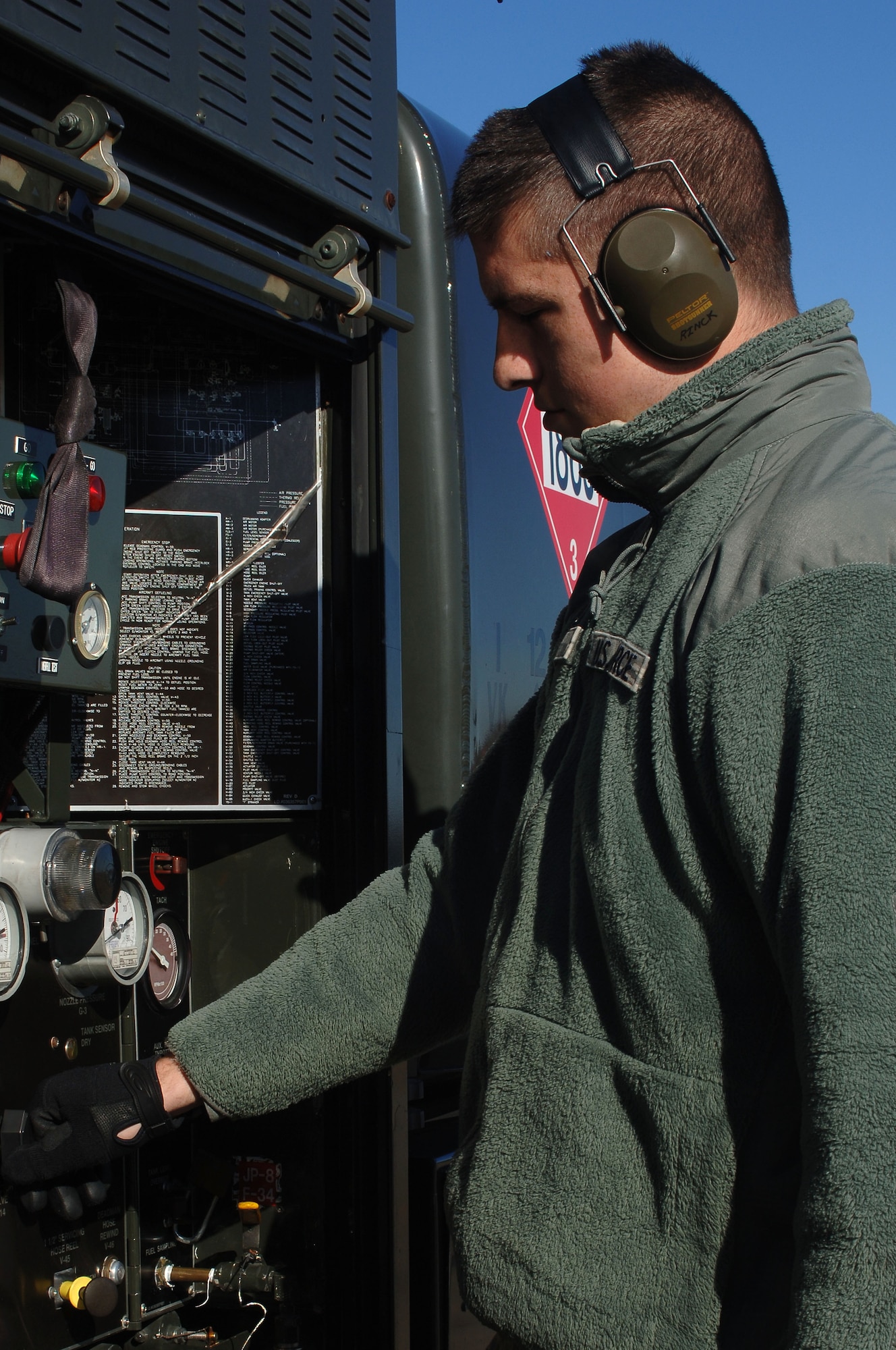U.S. Air Force Staff Sgt. David Rinck, 633rd Logistics Readiness Squadron fuels distribution operator,adjusts controls on an R-11 fuel truck for a “hot refuel” operation at Langley Air Force Base, Va., Dec. 13, 2013. 633rd LRS Airmen provide worldwide expeditionary combat logistics to one of Air Combat Command's largest fighter wings, providing fuel to approximately 40 F-22 Raptors. Rinck hails from Colora, Md. (U.S. Air Force photo by Senior Airman Teresa Aber/Released)