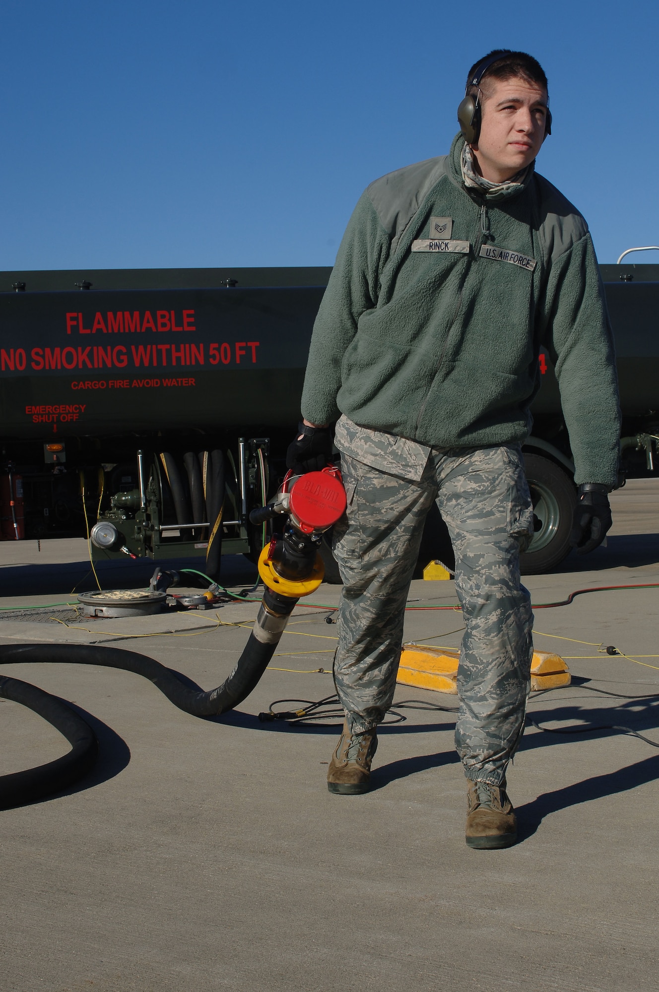 U.S. Air Force Staff Sgt. David Rinck, 633rd Logistics Readiness Squadron fuels distribution operator, carries a line from a Hydrant Mobile Refueler for a “hot refuel” operation at Langley Air Force Base, Va., Dec. 13, 2013. During “hot refueling”, Airmen refuel a jet while it is still running, allowing the jet to get airborne quickly. Rinck hails from Colora, Md. (U.S. Air Force photo by Senior Airman Teresa Aber/Released)
