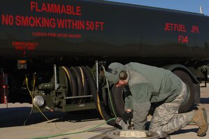 U.S. Air Force Staff Sgt. David Rinck, 633rd Logistics Readiness Squadron fuels distribution operator, connects hoses from a Hydrant Mobile Refueler to the underground hydrant system at Langley Air Force Base, Va., Dec. 13, 2013. The underground hydrant system allows fuel to be easily transported to the flightline. Rinck hails from Colora, Md. (U.S. Air Force photo by Senior Airman Teresa Aber/Released)