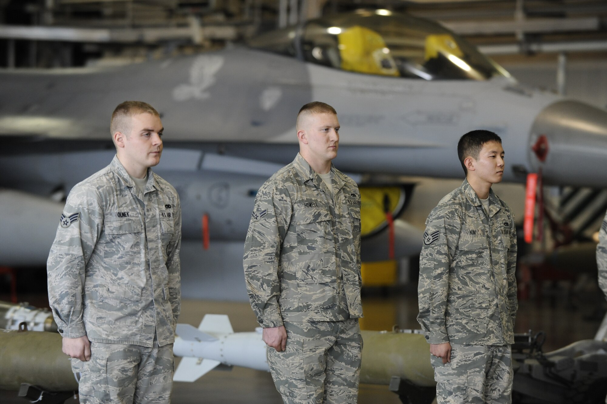 Senior Airman Ronald Olney, Airman 1st Class Michael Howell and Staff Sgt. Stephan Kim, members of the 13th Aircraft Maintenance Unit weapons load crew, stand at attention before the beginning of the Weapons Load Crew of the Year competition at Misawa Air Base, Japan, Jan. 17, 2014. The team competed against the 14th AMU to see who could load armaments on the F-16 the fastest with the least discrepancies. The winner of the competition will be announced in March. (U.S. Air Force photo/Airman 1st Class Patrick S. Ciccarone)