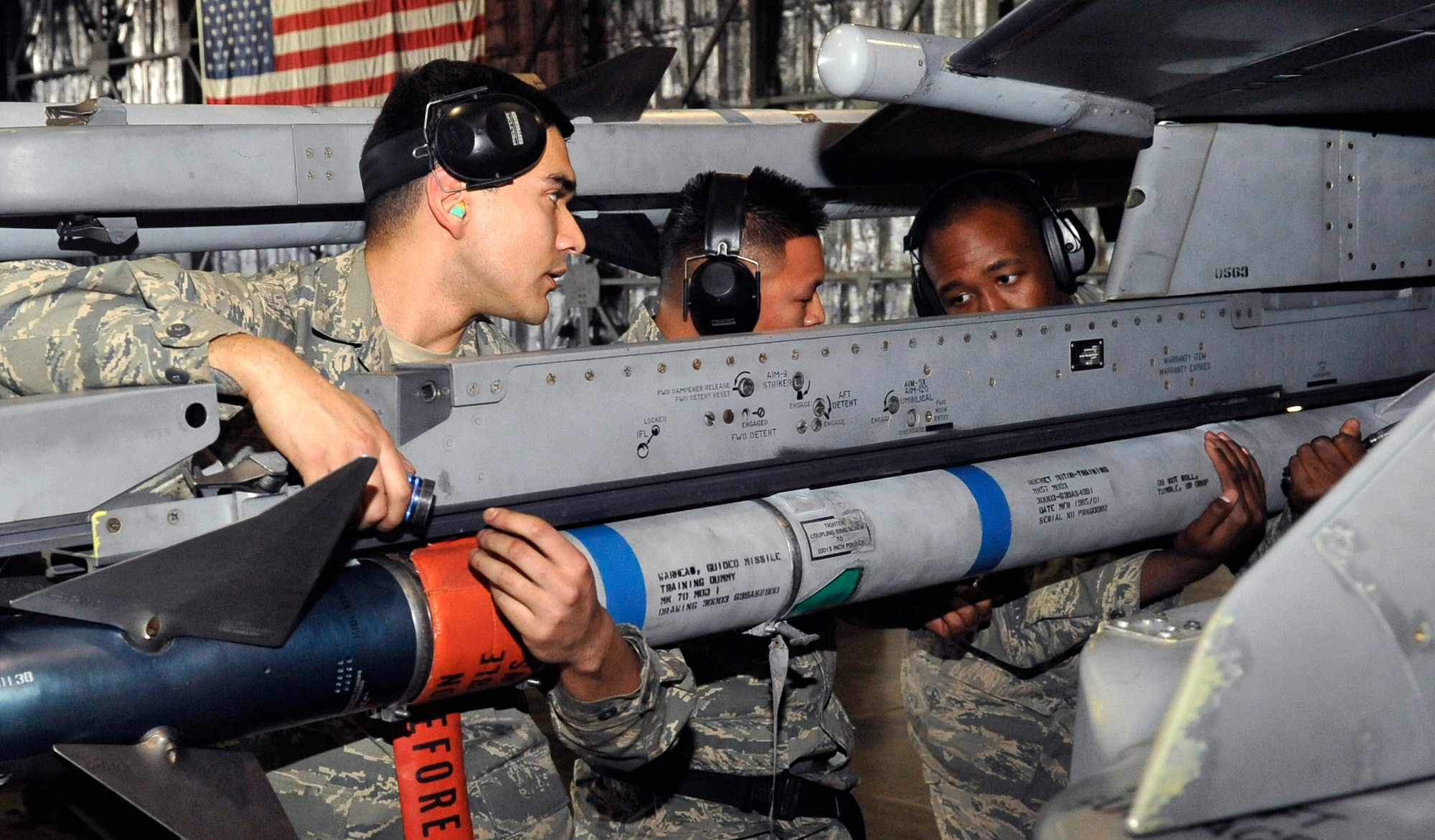 Airman 1st Class Jesse Garza, Staff Sgt. Gregorio Luis and Senior Airman Rashad Holmes, 14th Aircraft Maintenance Unit weapons load crew  members, load an AIM-9 Sidewinder onto an F-16 Fighting Falcon during the Weapons Load Crew of the Year competition at Misawa Air Base, Japan, Jan. 17, 2014. Three-man load crews representing the 13th and 14th AMU battled it out to see who would earn the title of Weapons Load Crew of the Year. (U.S. Air Force photo by Airman 1st Class Zachary Kee)