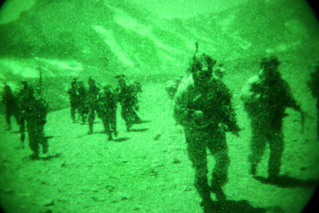 As seen through a night-vision device, U.S. and Afghan special forces soldiers patrol up a mountain during an operation in the Ghorband district of Afghanistan's Parwan province, Jan. 15, 2014.