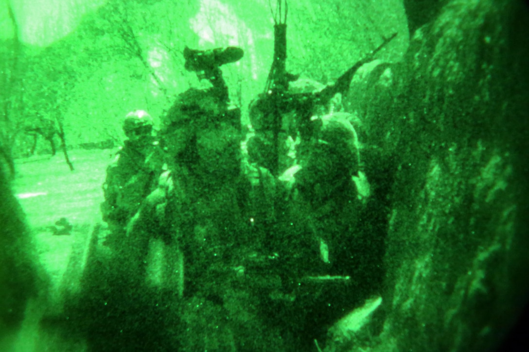 As seen through a night-vision device, U.S. and Afghan army special forces soldiers take cover fire from insurgents during a firefight in the Ghorband district of Afghanistan's Parwan province, Jan. 15, 2014.