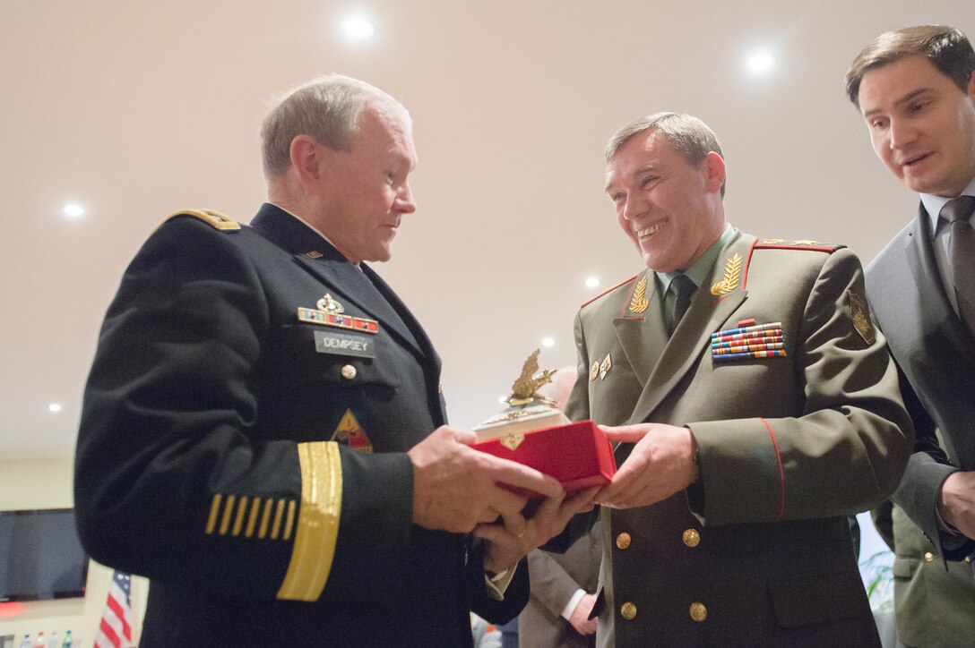 U.S. Army Gen. Martin E. Dempsey, left, chairman of the Joint Chiefs of Staff, accepts a gift from his Russian counterpart, Gen. Valery V. Gerasimov, during a meeting in Brussels, Jan. 21, 2014. 