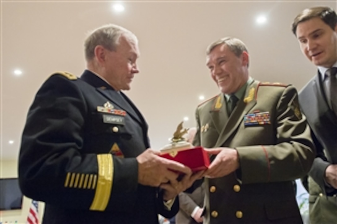 U.S. Army Gen. Martin E. Dempsey, left, chairman of the Joint Chiefs of Staff, accepts a gift from his Russian counterpart, Gen. Valery V. Gerasimov, during a meeting in Brussels, Jan. 21, 2014. Dempsey is on a three-day trip during which he also is scheduled to meet with his NATO counterparts.