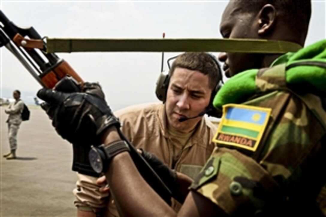 U.S. Air Force Senior Airman Chase Vento inspects the weapon of a Rwandan soldier before allowing him on the C-17 Globemaster III in Kigali, Rwanda, Jan. 19, 2014. U.S. forces will transport 850 Rwandan soldiers and more than 1,000 tons of equipment into the Central African Republic to aid French and African Union operations against militants during a three-week operation. Vento is assigned to the 627th Security Forces Squadron Phoenix Raven.  