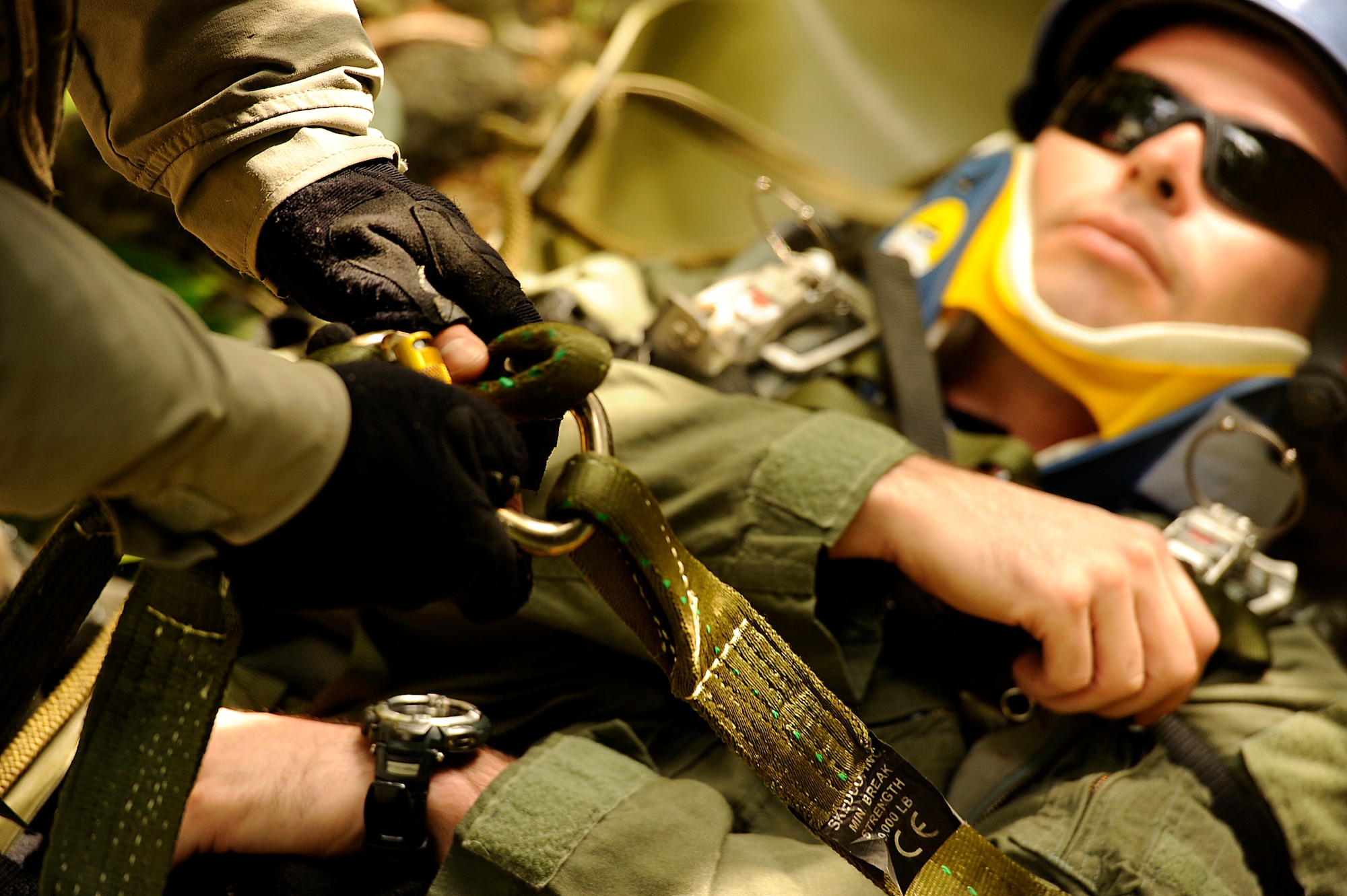 U.S. Air Force Staff Sgt. Joshua Cunningham, 31st Rescue Squadron pararescueman, connects a harness to Staff Sgt. George Reed, 31st RQS pararescueman and simulated parachute catch victim, and prepares to be hoisted up a bridge during element leader upgrade training on Kadena Air Base, Japan, Jan. 22, 2014. Pararescuemen frequently train in a multitude of rescue scenarios in order to be prepared for any environment or situation and maintain proficiency. (U.S. Air Force photo by Senior Airman Maeson L. Elleman)