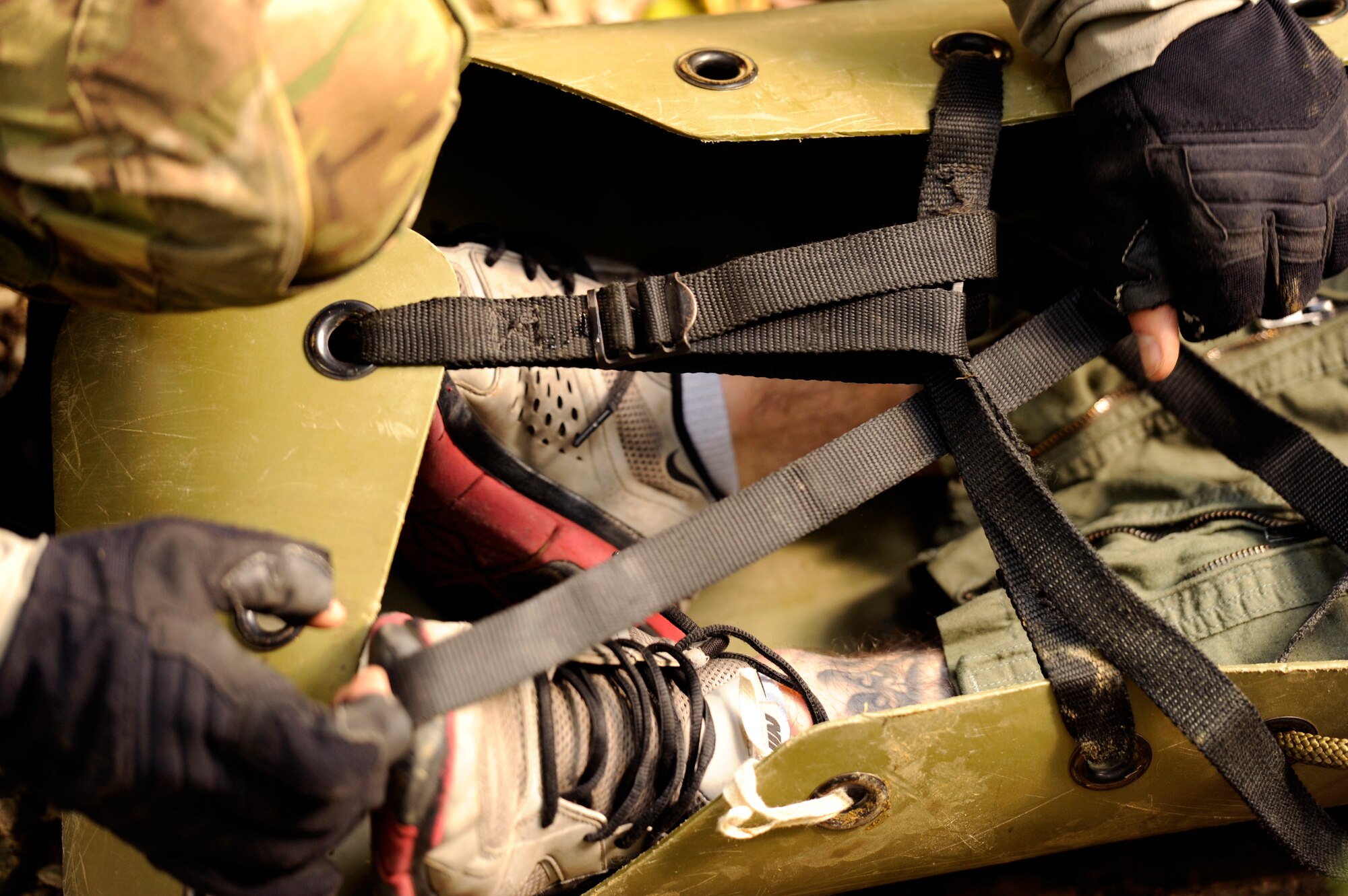 U.S. Air Force Staff Sgt. Joshua Cunningham, 31st Rescue Squadron pararescueman, straps down Staff Sgt. George Reed, 31st RQS pararescueman and simulated parachute catch victim, and prepares to be hoisted up a bridge during element leader upgrade training on Kadena Air Base, Japan, Jan. 22, 2014. In order for a pararescueman to become an element leader, the individual must complete several rescue-related tasks and challenges. (U.S. Air Force photo by Senior Airman Maeson L. Elleman)