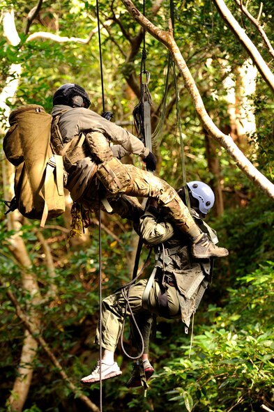 U.S. Air Force Staff Sgt. Joshua Cunningham, 31st Rescue Squadron pararescueman, braces Staff Sgt. George Reed, 31st RQS pararescueman and simulated parachute catch victim, as the two are suspended from a bridge during element leader upgrade training on Kadena Air Base, Japan, Jan. 22, 2014. In order for a pararescueman to become an element leader, the individual must complete several rescue-related tasks and challenges. During the training, the pararescue team practiced several rescue techniques in order to maintain proficiency and prepare for potential real-world scenarios. (U.S. Air Force photo by Senior Airman Maeson L. Elleman)