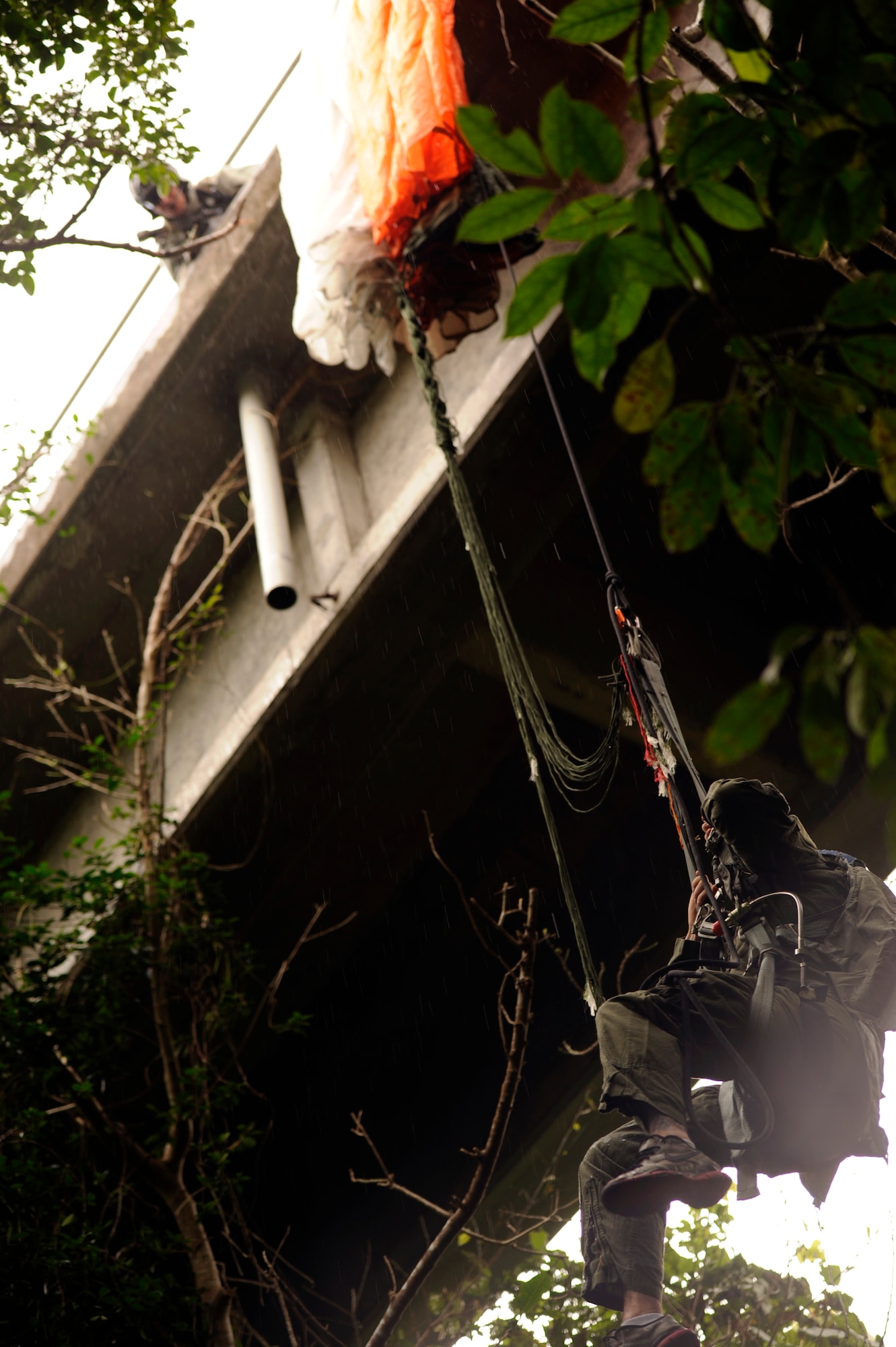 A U.S. Air Force pararescueman from the 31st Rescue Squadron calls down to U.S. Air Force Staff Sgt. George Reed, 31st RQS pararescueman and simulated caught parachute victim, during element leader upgrade training on Kadena Air Base, Japan, Jan. 22, 2014. Pararescuemen frequently train in a multitude of rescue scenarios in order to be prepared for any environment or situation and maintain proficiency. (U.S. Air Force photo by Senior Airman Maeson L. Elleman)