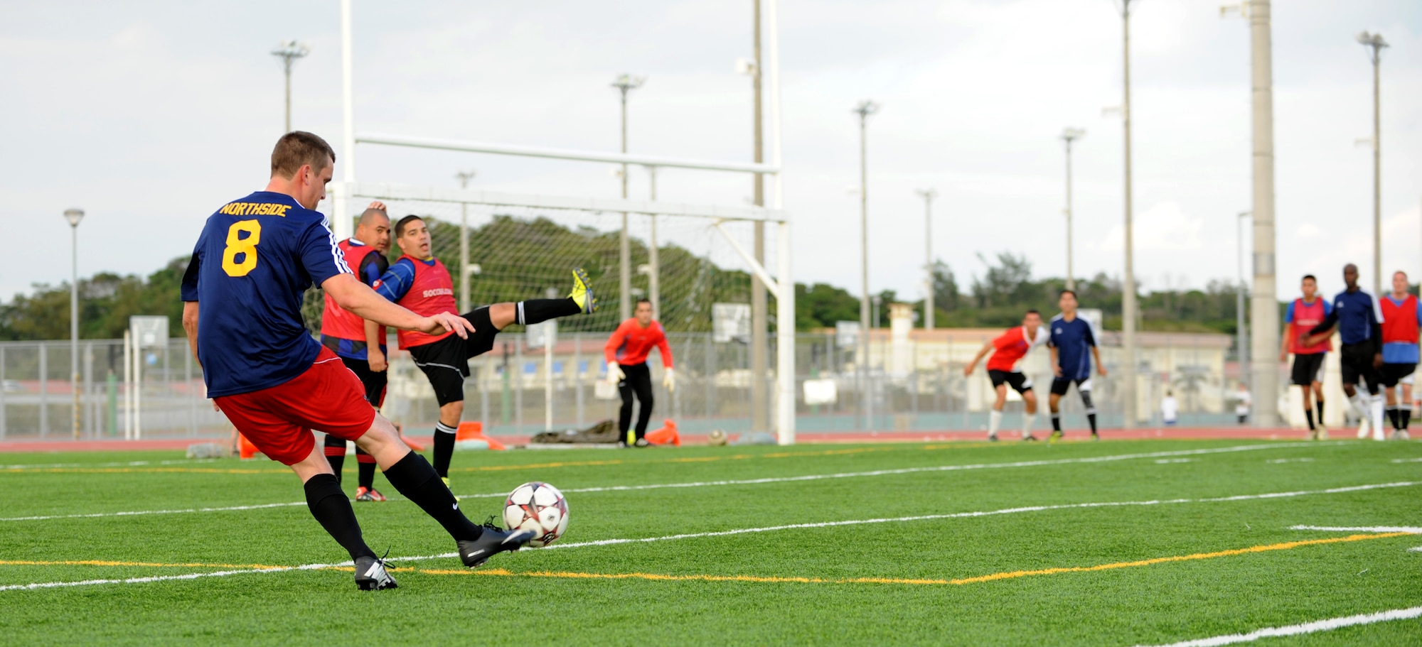 A member of the 718th Aircraft Maintenance Squadron intramural soccer team kicks the soccer ball in an attempt to score a goal on Kadena Air Base, Japan, Jan. 12, 2014. The 18th AMXS and 18th Component Maintenance Squadron faced off in a soccer intramural playoff game, ending with the 18th CMS winning a spot in the playoffs. (U.S. Air Force photo by Airman 1st Class Keith James)