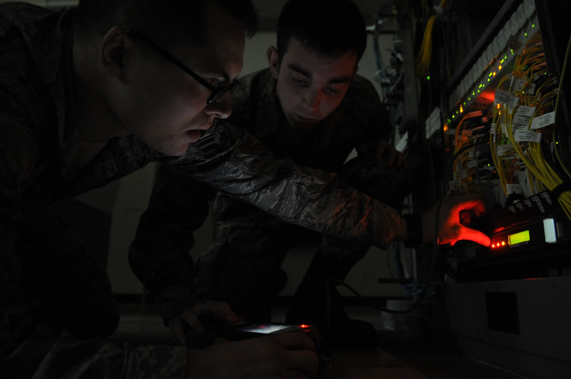 U.S. Air Force Airmen 1st Class Jason Dwyer, 18th Communications tech control, and Jakeob Scaglione, tech control facility technician, troubleshoot a circuit inside of their tech control facility on Kadena Air Base, Japan, Jan. 21, 2014. The tech control section of the 18th CS long hauls all telecommunication that leaves Kadena. The 18th CS was recently awarded the Information Dominance Unit Award and Air Force Large Postal Facility Award. (U.S. Air Force photo by Airman 1st Class Keith James)