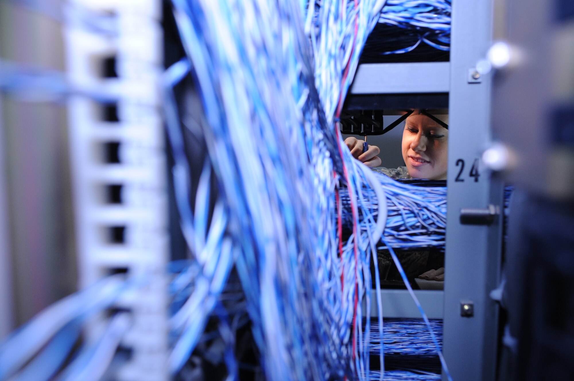 U.S. Air Force Airman 1st Class Kacie Berry, 18th Communications Squadron cyber transport technician, installs a phone on a main distribution frame on Kadena Air Base, Japan, Jan. 21, 2014. The 18th CS is the second largest communications squadron in the Air Force, providing fixed and mobile communications for 24,000 people, six major commands, 29 tenant units, and joint services. (U.S. Air Force photo by Airman 1st Class Keith James)